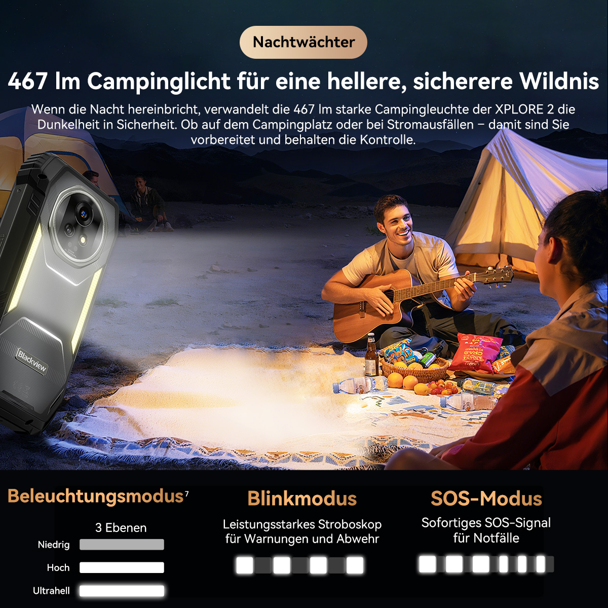 Ein Mann spielt Gitarre am Lagerfeuer. Eine Frau sitzt bei ihm. Ein Telefon mit Taschenlampe leuchtet den Bereich aus. Ein Zelt ist hinten.