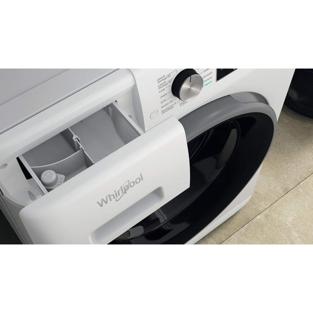 Primo piano di una lavatrice Whirlpool bianca. Il cassetto del detersivo è aperto, rivelando scomparti. Il pannello di controllo è visibile.