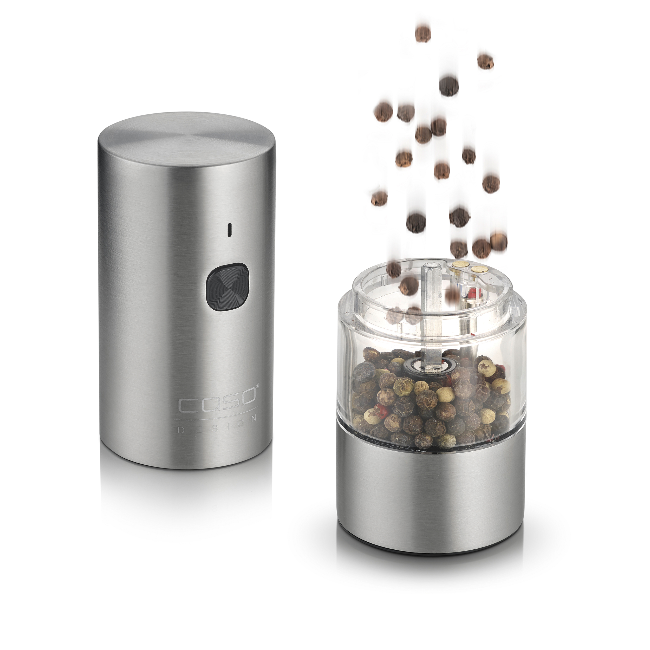 Eine Metall-Pfeffermühle mit Pfefferkörnern, die in den transparenten Behälter fallen. Eine zweite Mühle links.
