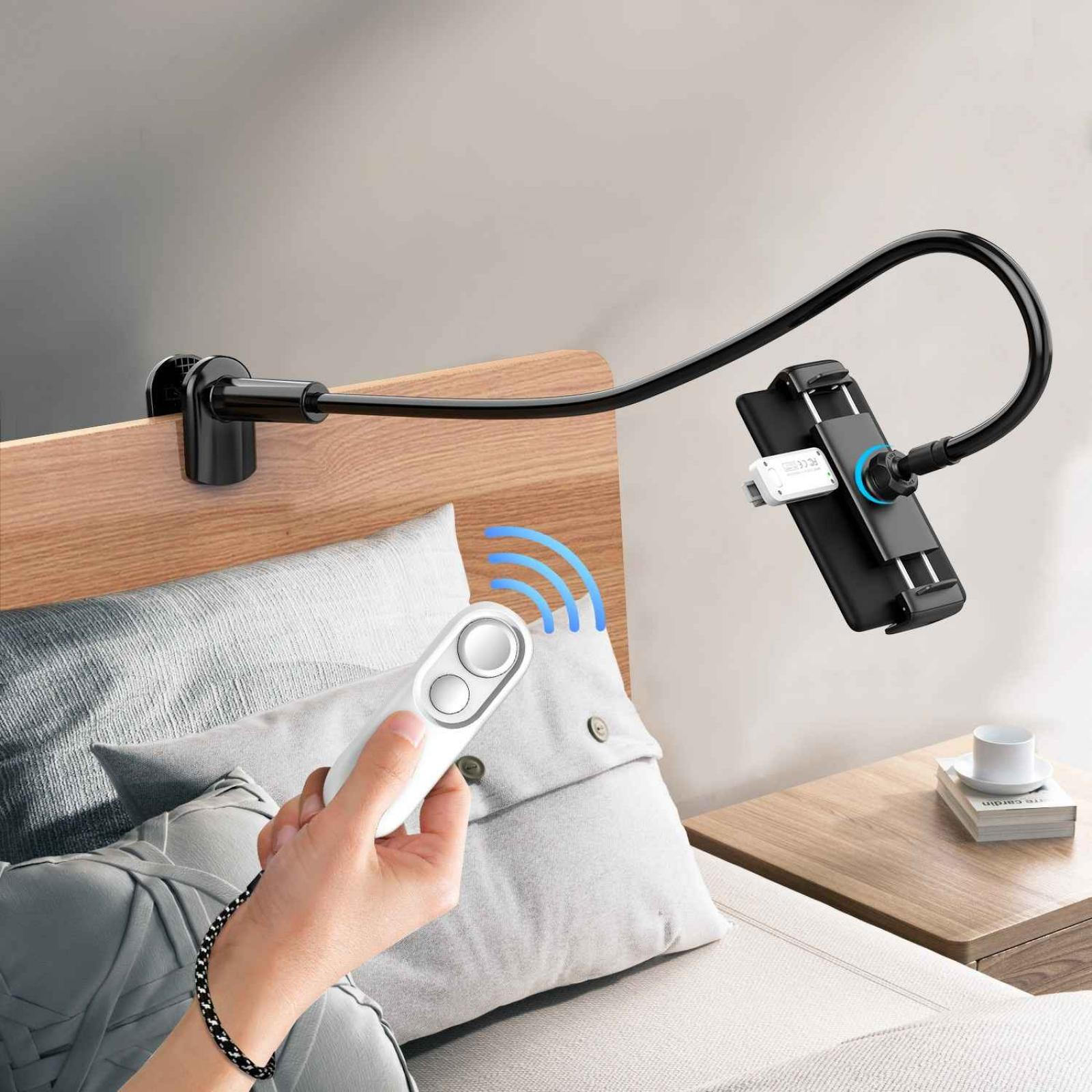 Ein Telefonhalter ist am Bett befestigt. Eine Hand hält eine Fernbedienung. Blaue Wellen kommen davon.