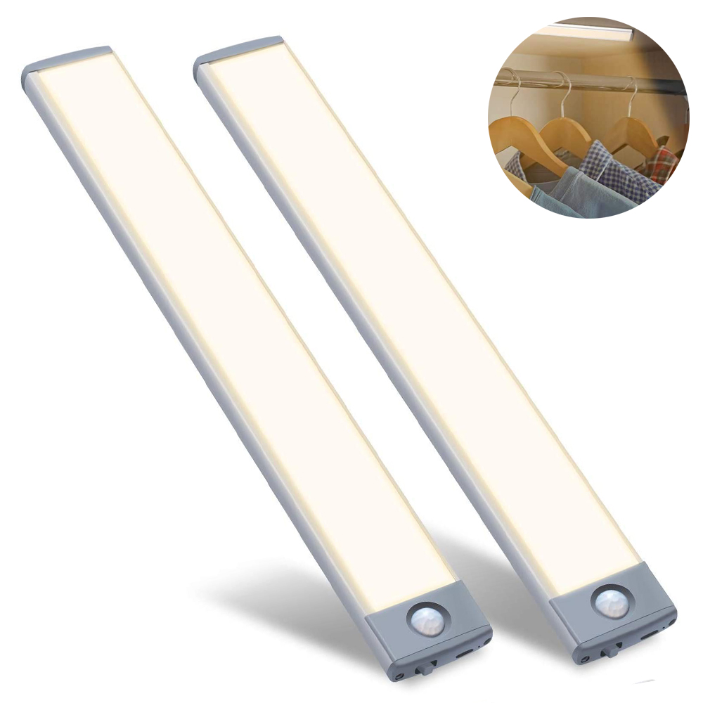 Zwei LED-Streifen mit einem Detail des Schranks im Hintergrund. Die Lichter sind silber und weiß. Kleidung hängt an Holzbügeln.