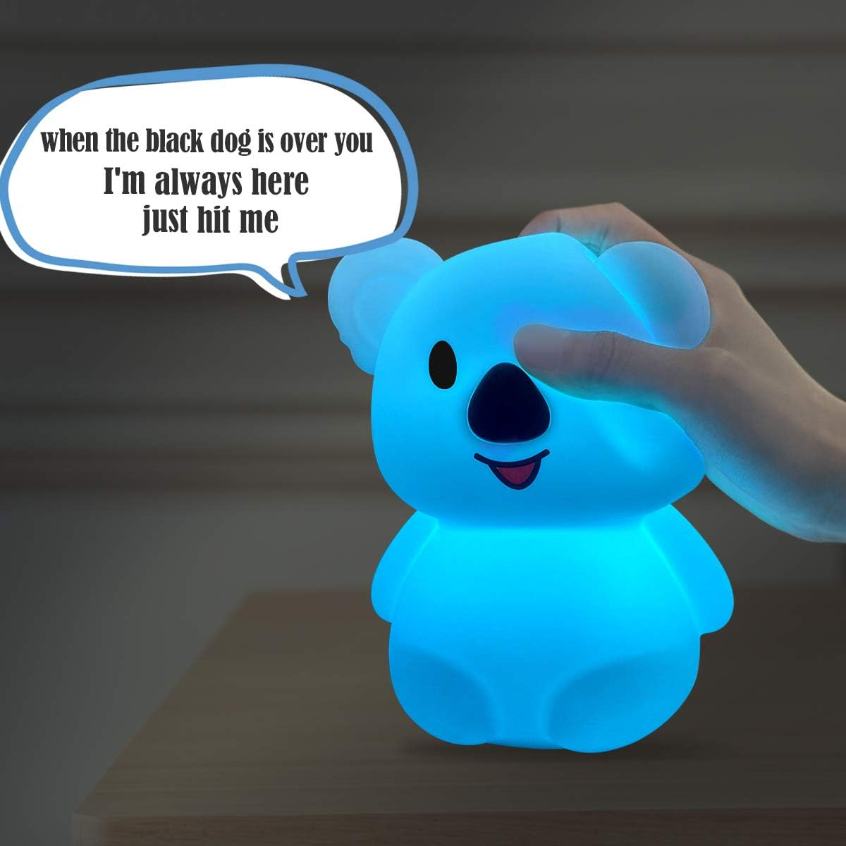 Eine leuchtend blaue Koala-Lampe mit einer Sprechblase mit der Aufschrift 'Ich bin immer hier, schlag einfach zu'. Eine Hand berührt die Lampe.
