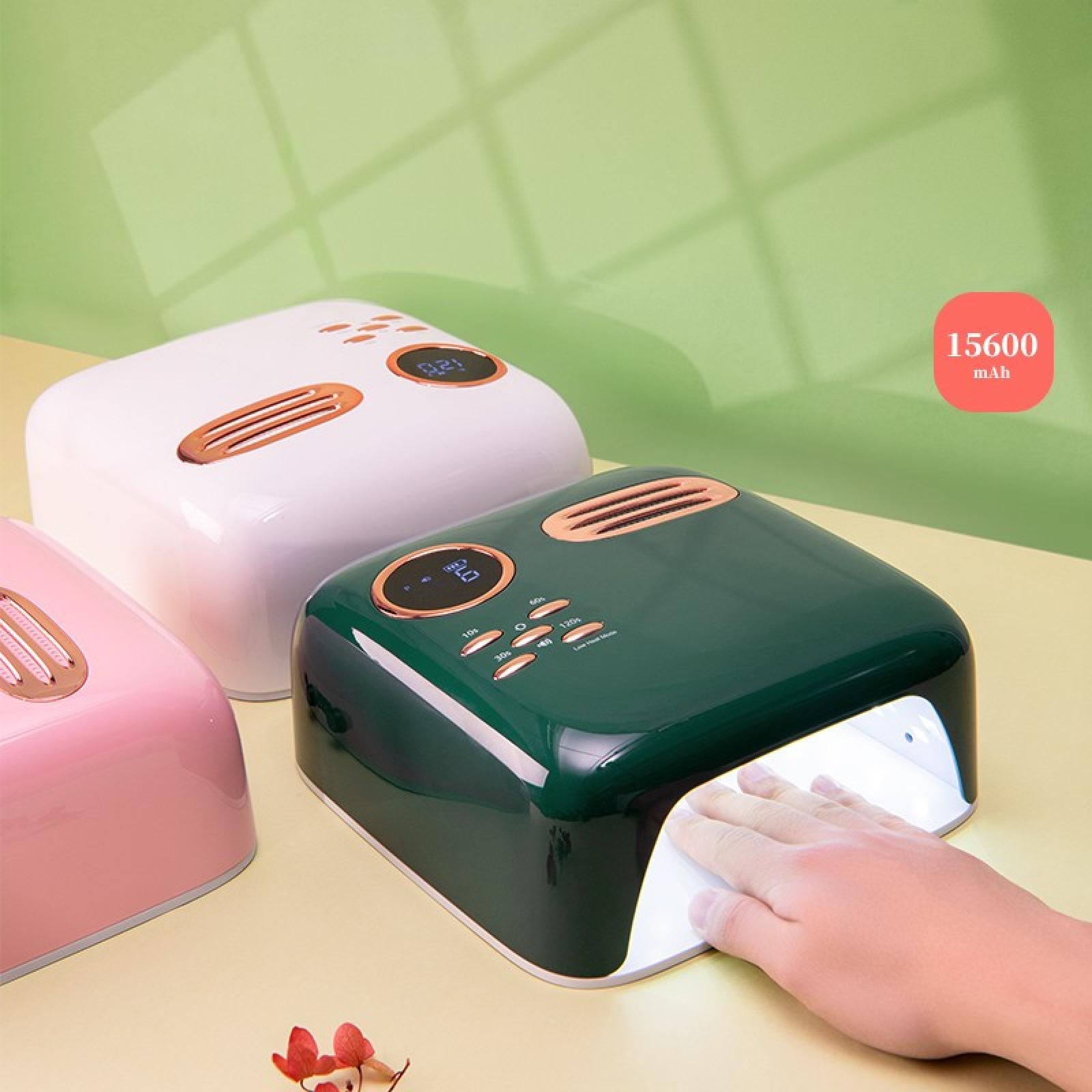 Drei Nagellampen in Rosa, Weiß und Grün, mit einer Hand in der grünen Lampe. Ein rotes Quadrat zeigt 15600 mAh.