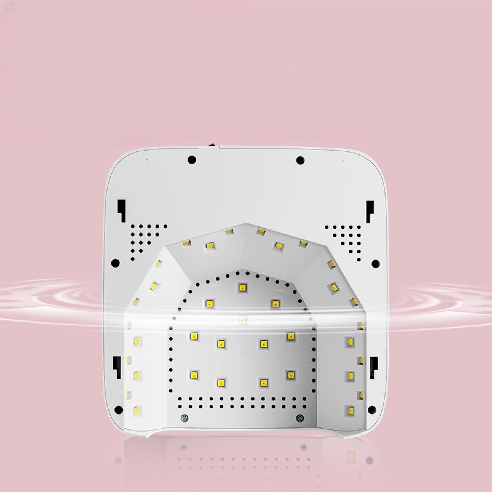 Eine weiße LED-Nagellampe auf rosa Hintergrund. Sie hat mehrere gelbe Lichter und eine abgerundete quadratische Form.