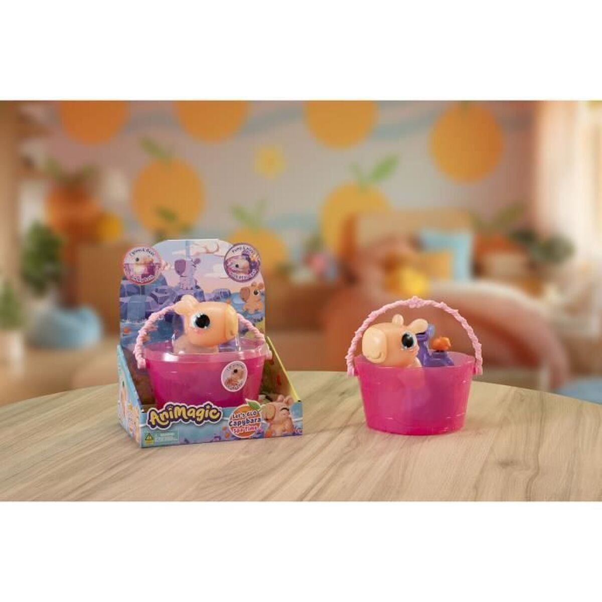 Zwei Spielzeug-Wasserschweine in rosa Eimern. Eines befindet sich in einer Box, das andere ist freistehend. Der Hintergrund hat eine Wand mit orangefarbenen Kreisdesigns.