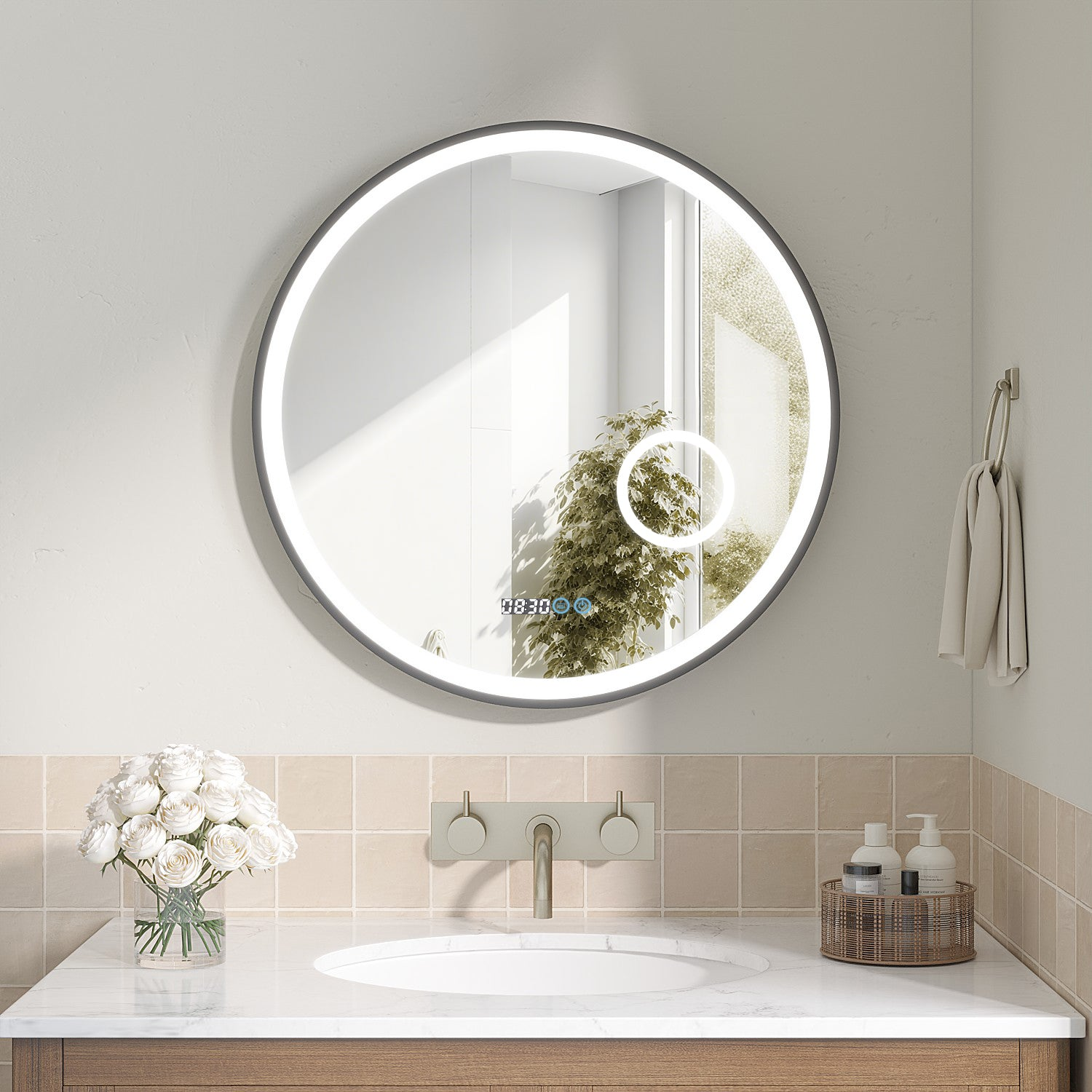 Ein runder Spiegel mit Lichtern über einem Waschbecken. Ein Strauß weißer Rosen und Toilettenartikel befinden sich auf der Theke.