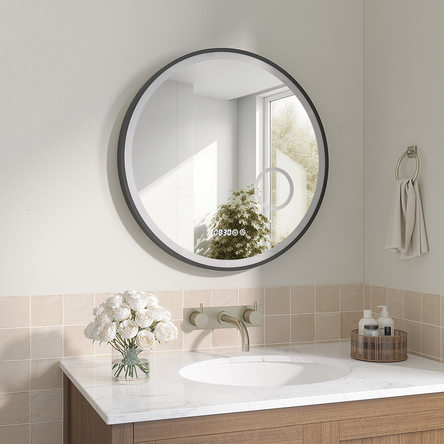 Badezimmer mit rundem Spiegel, weißen Rosen und einem Waschbecken. Ein Handtuch hängt an einem Ring. Beige Fliesen und ein Holzschrank sind sichtbar.