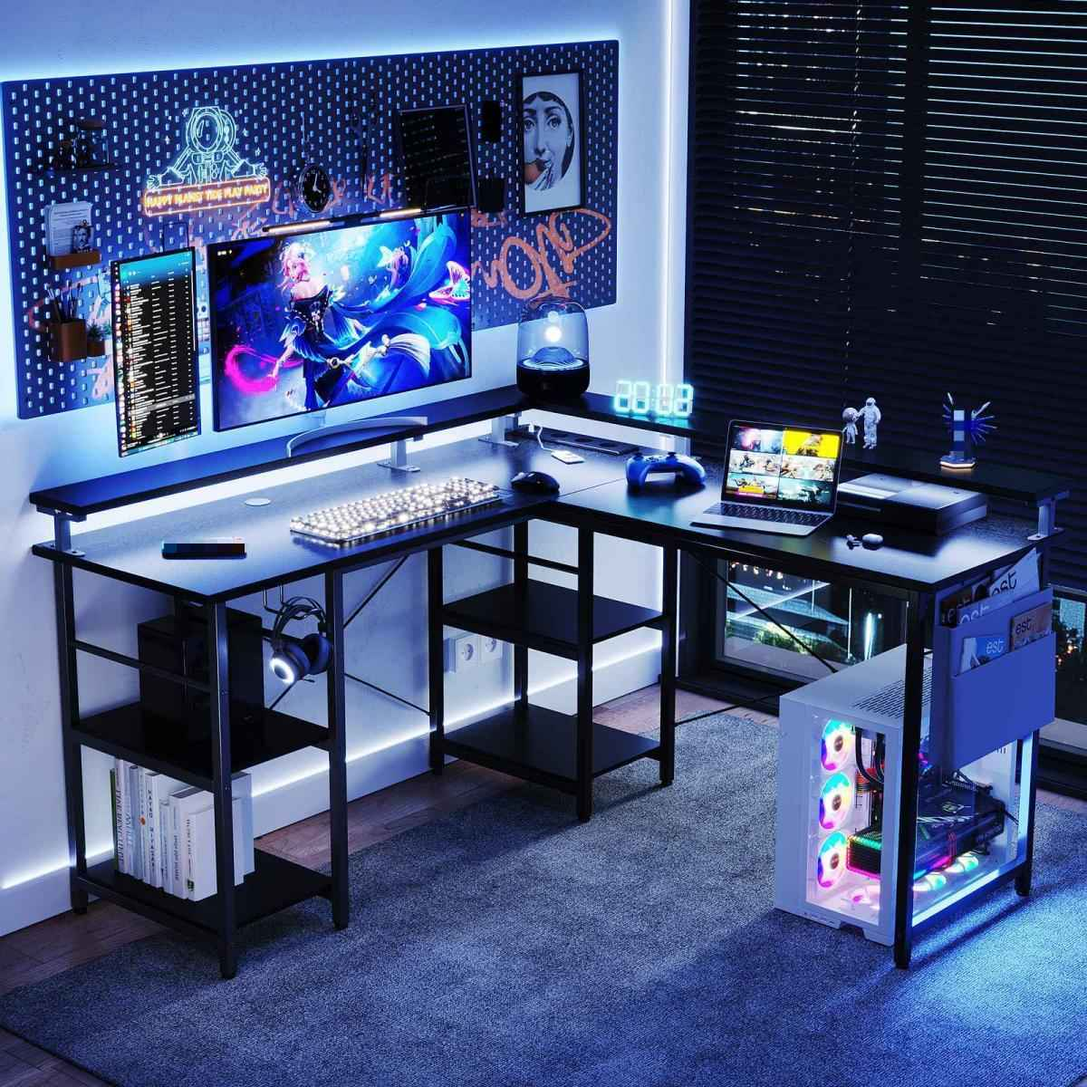Ein Gaming-Setup mit schwarzem Schreibtisch, mehreren Monitoren und einem Computer mit bunten Lichtern. Der Raum ist schwach mit blauen Akzenten beleuchtet.