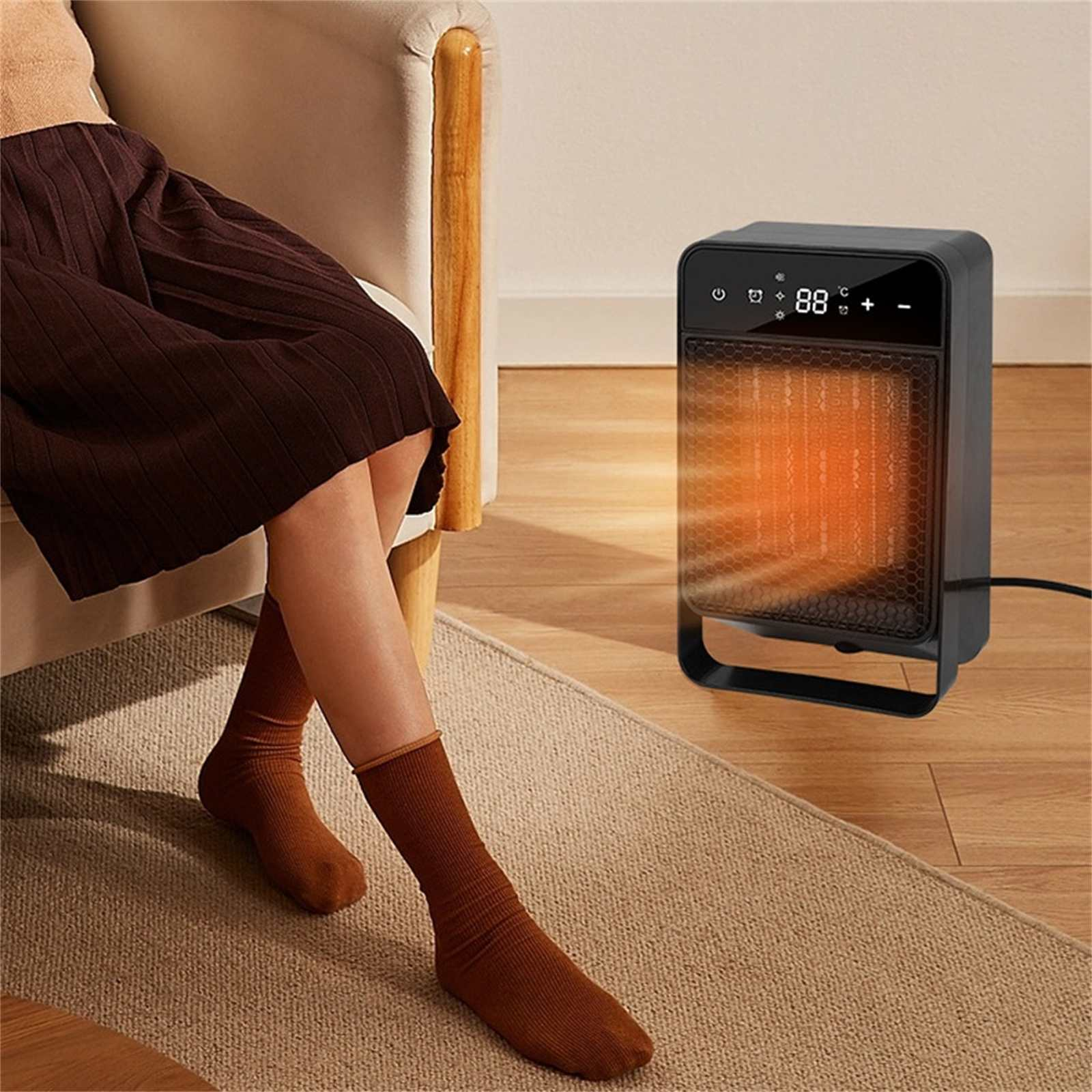 Eine Person sitzt in der Nähe eines schwarzen Heizgeräts. Das Heizgerät zeigt 88 Grad an. Die Person trägt braune Socken und einen braunen Rock.