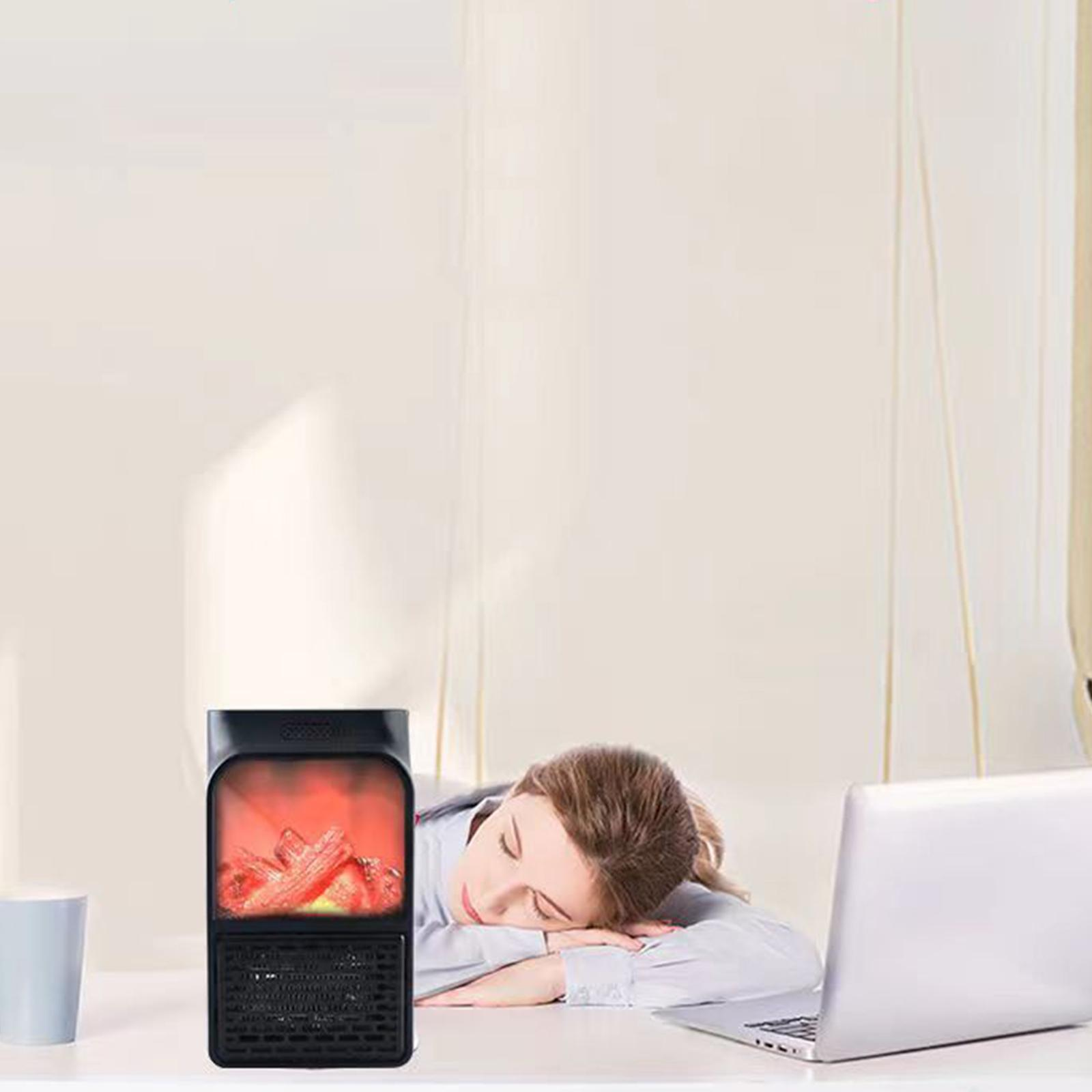 Eine Frau schläft am Schreibtisch mit Laptop und einem kleinen Heizgerät mit Feuerbild.