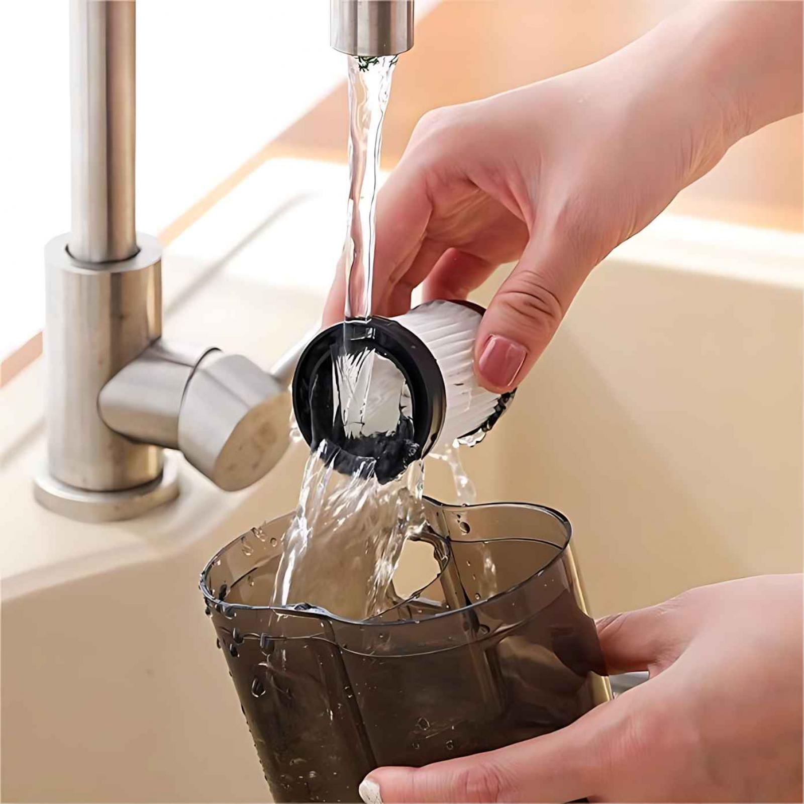 Eine Person spült einen Staubsaugerfilter unter einem Wasserhahn ab. Wasser fließt aus dem Wasserhahn in den Filter und einen Behälter.