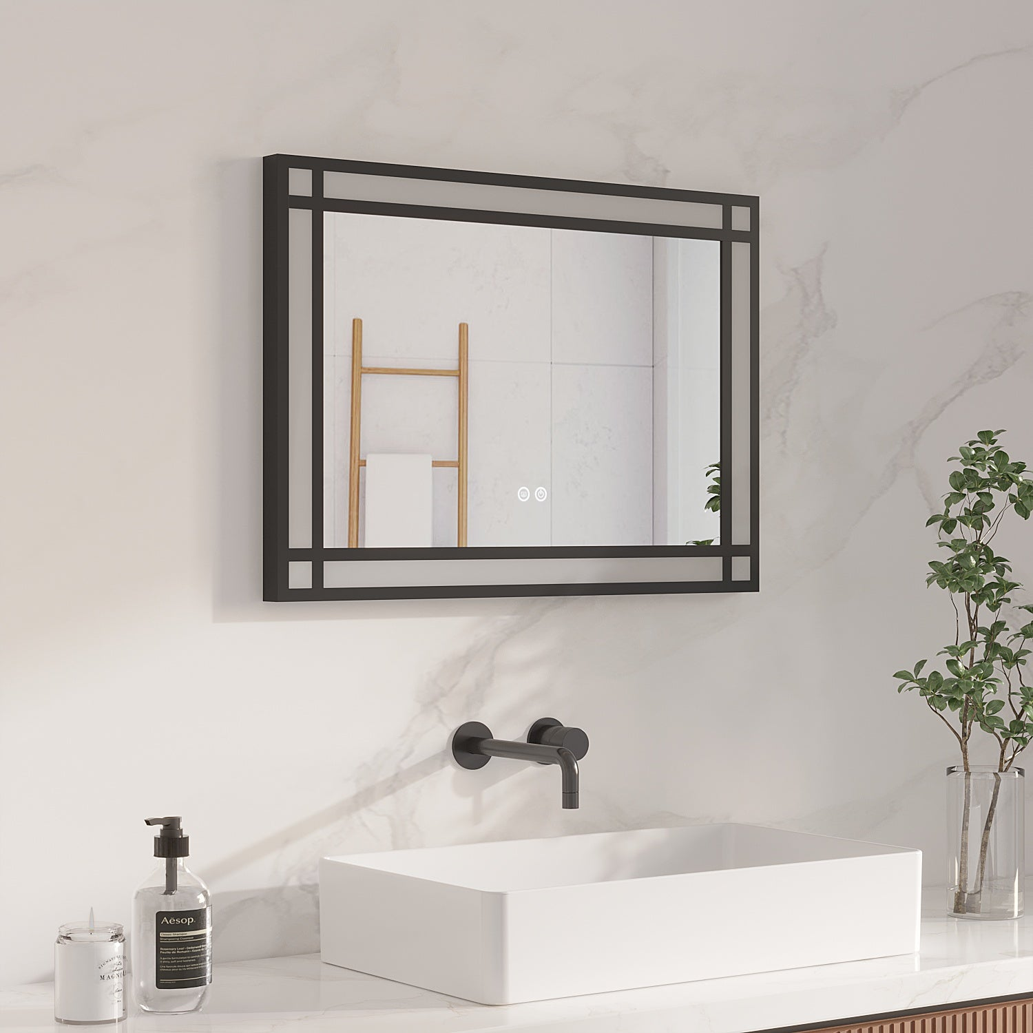 Badezimmer-Szene mit einem schwarz gerahmten Spiegel über einem weißen Waschbecken. Wasserhahn, Seife und Pflanze sichtbar.