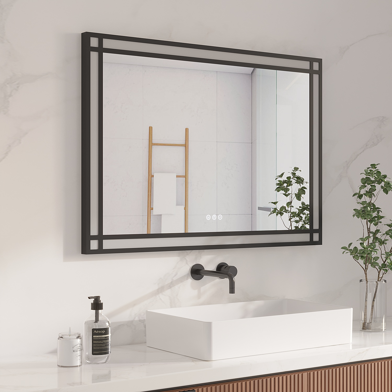 Badezimmer mit quadratischem Spiegel, schwarzem Rahmen, weißem Waschbecken, Marmor-Arbeitsplatte und Pflanzen. Seife und Kerze stehen auf der Theke.