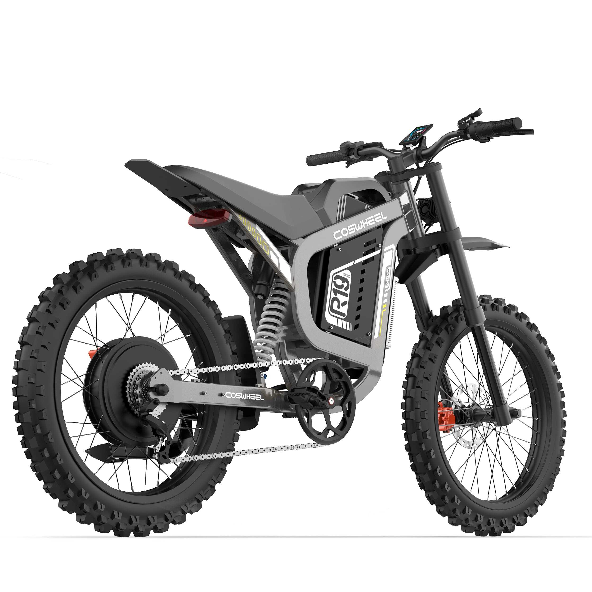 Elektryczny motocykl terenowy, szary i czarny, na białym tle. Posiada duże opony, zawieszenie i wyświetlacz cyfrowy.