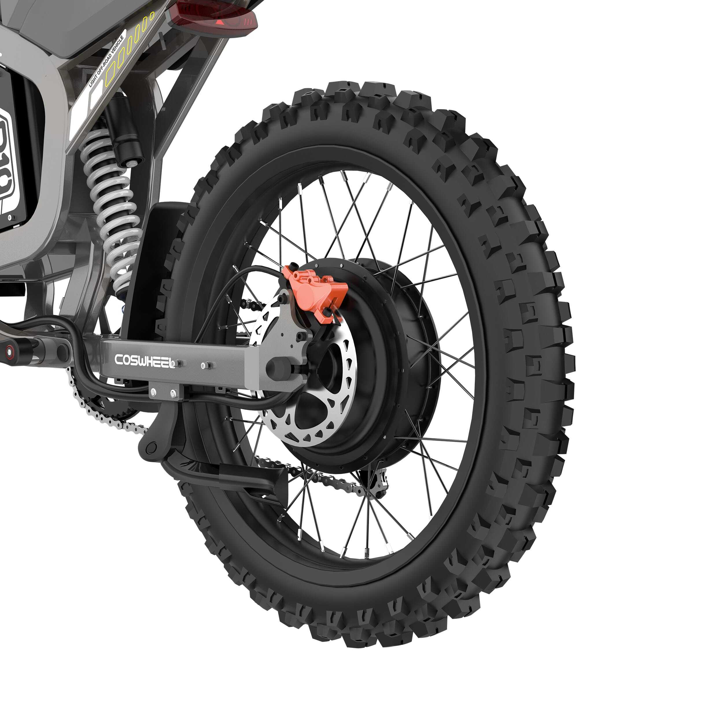 Zbliżenie czarnej opony motocyklowej z pomarańczowym zaciskiem hamulcowym. Opona ma głęboki bieżnik.