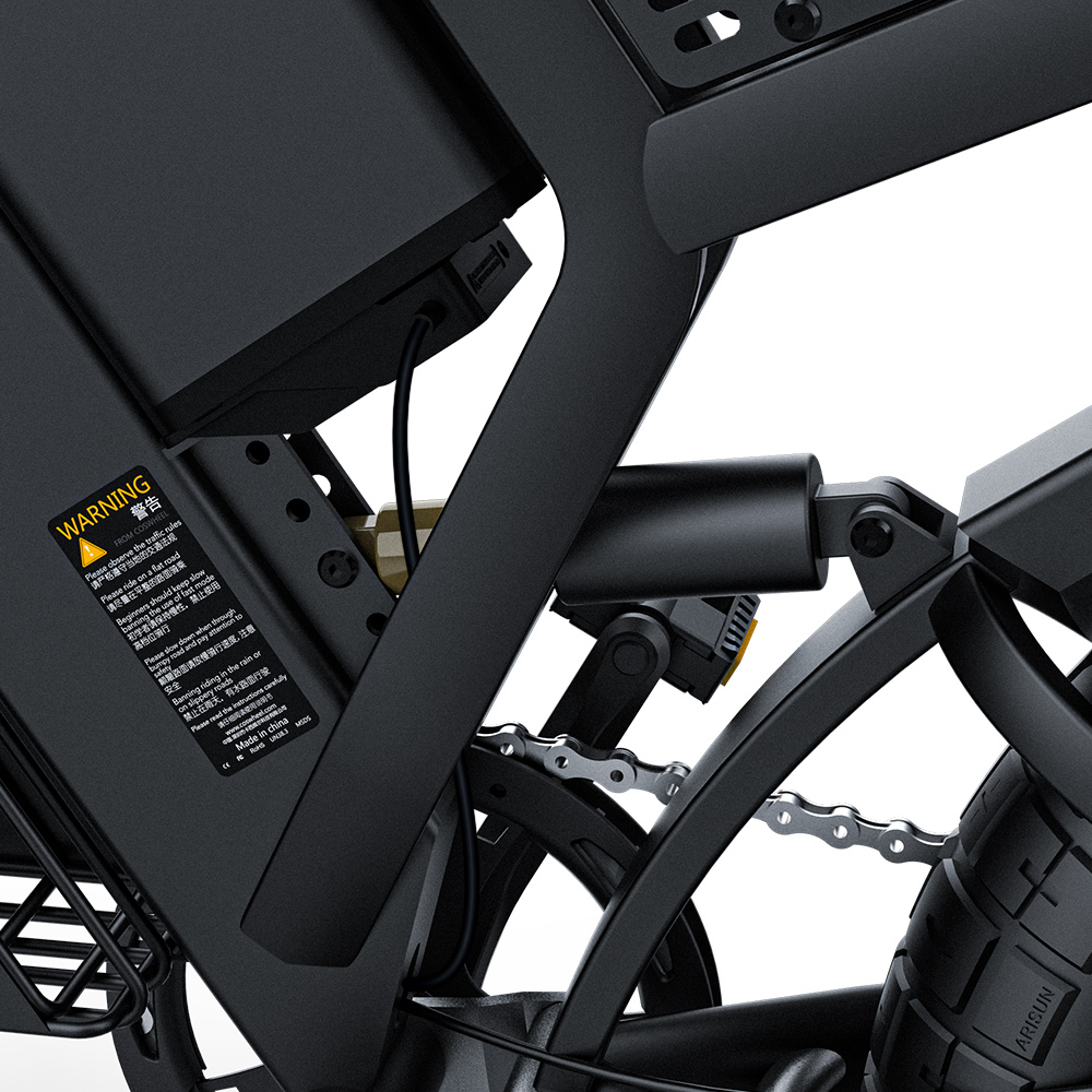 Zbliżenie czarnej ramy roweru elektrycznego. Widoczny łańcuch, zawieszenie, bateria i naklejka ostrzegawcza.