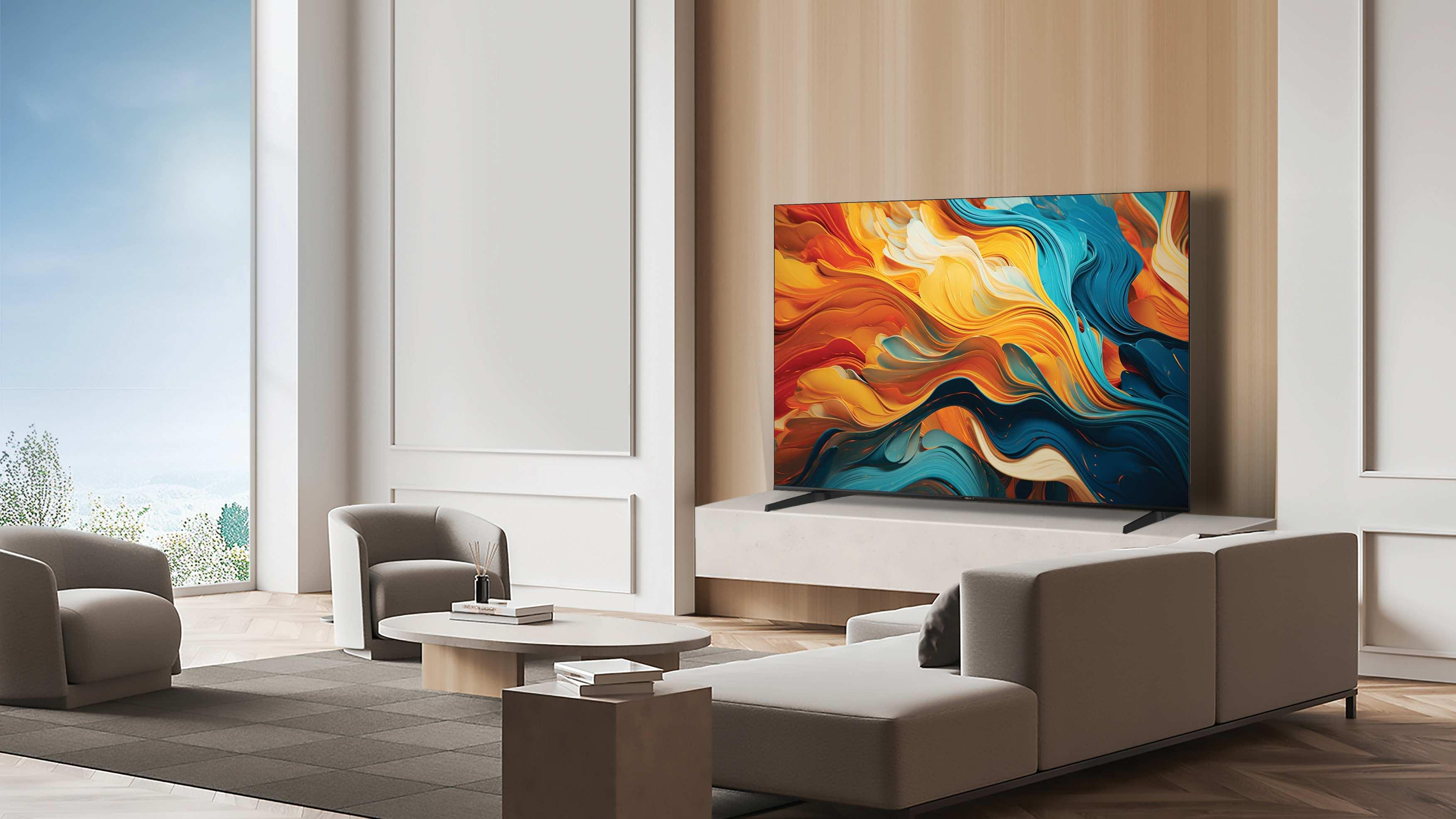 Salón con un televisor grande que muestra arte abstracto. Incluye sofá, sillas, mesa de café y una vista brillante de la ventana.