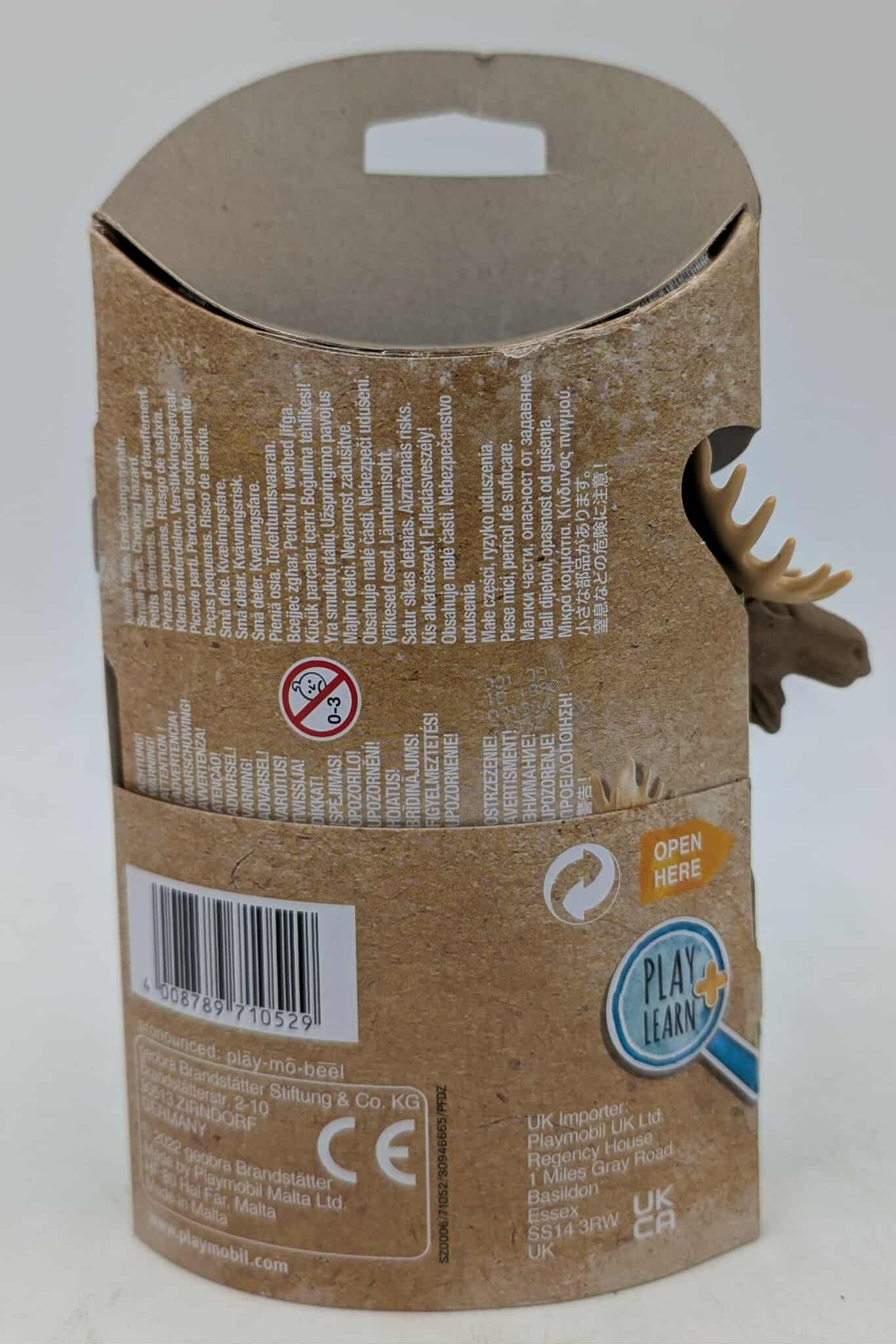 Braune Pappschachtel mit Text und einem Spielzeug-Elchkopf. Die Schachtel hat einen Barcode und ein Label 'Play & Learn'.