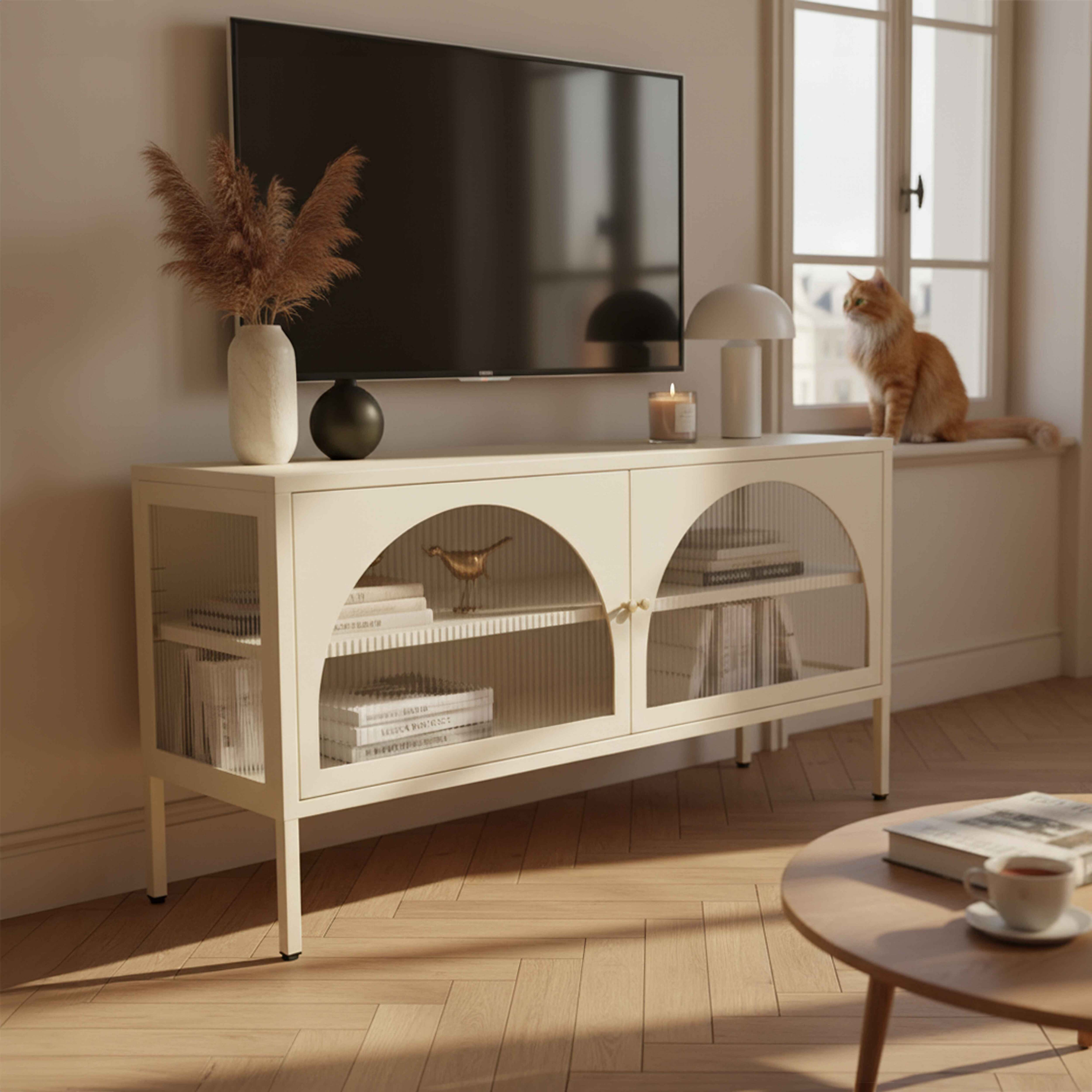 Ein Wohnzimmer mit Fernseher, Schrank, Fenster und Katze. Ein Tisch mit einer Tasse Tee steht vorne.