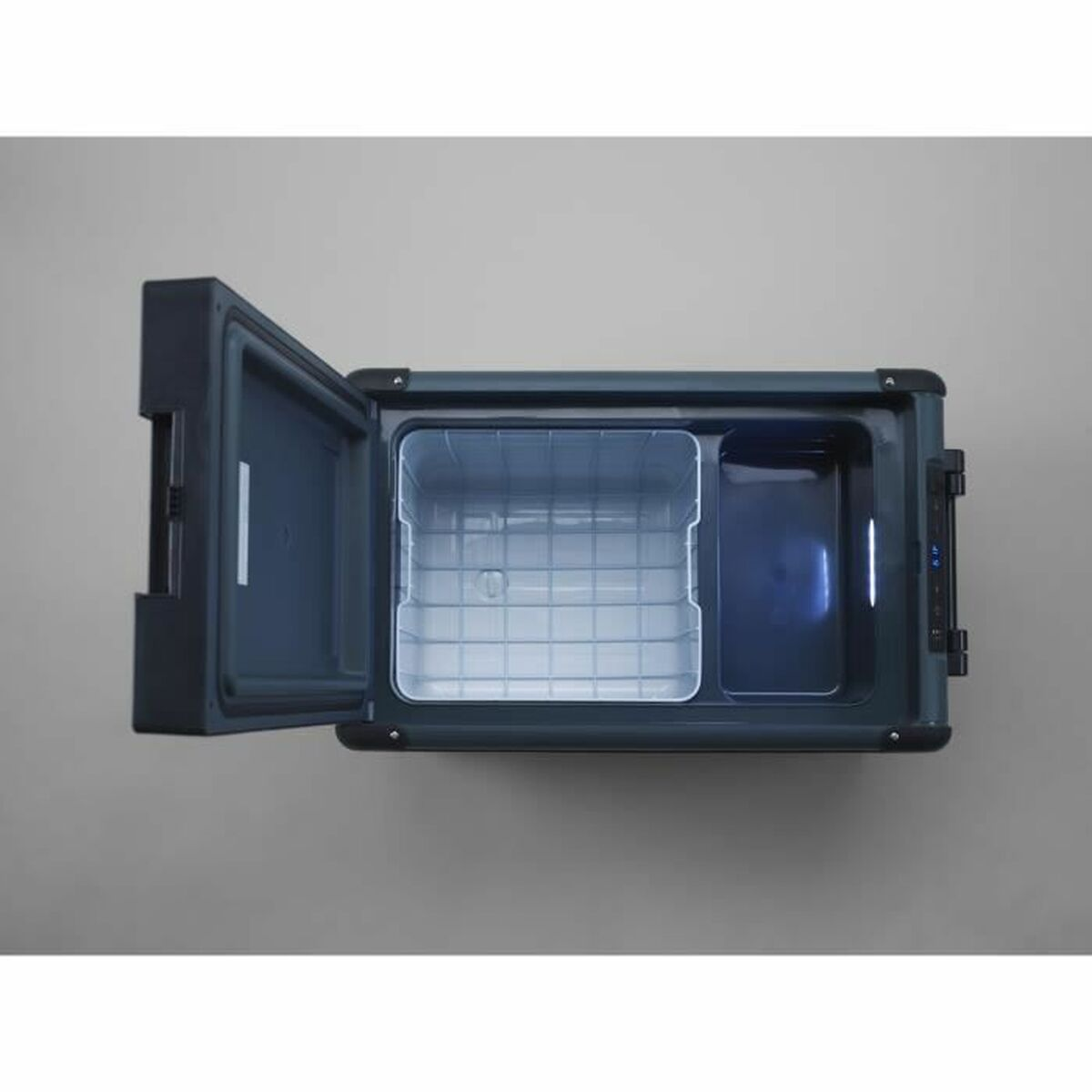 Otwarta przenośna lodówka z otwartymi drzwiami. W środku dwa przedziały. Tło to szara powierzchnia.