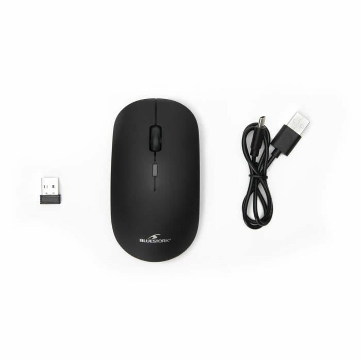 Un ratón inalámbrico negro con receptor USB y cable de carga sobre un fondo blanco.