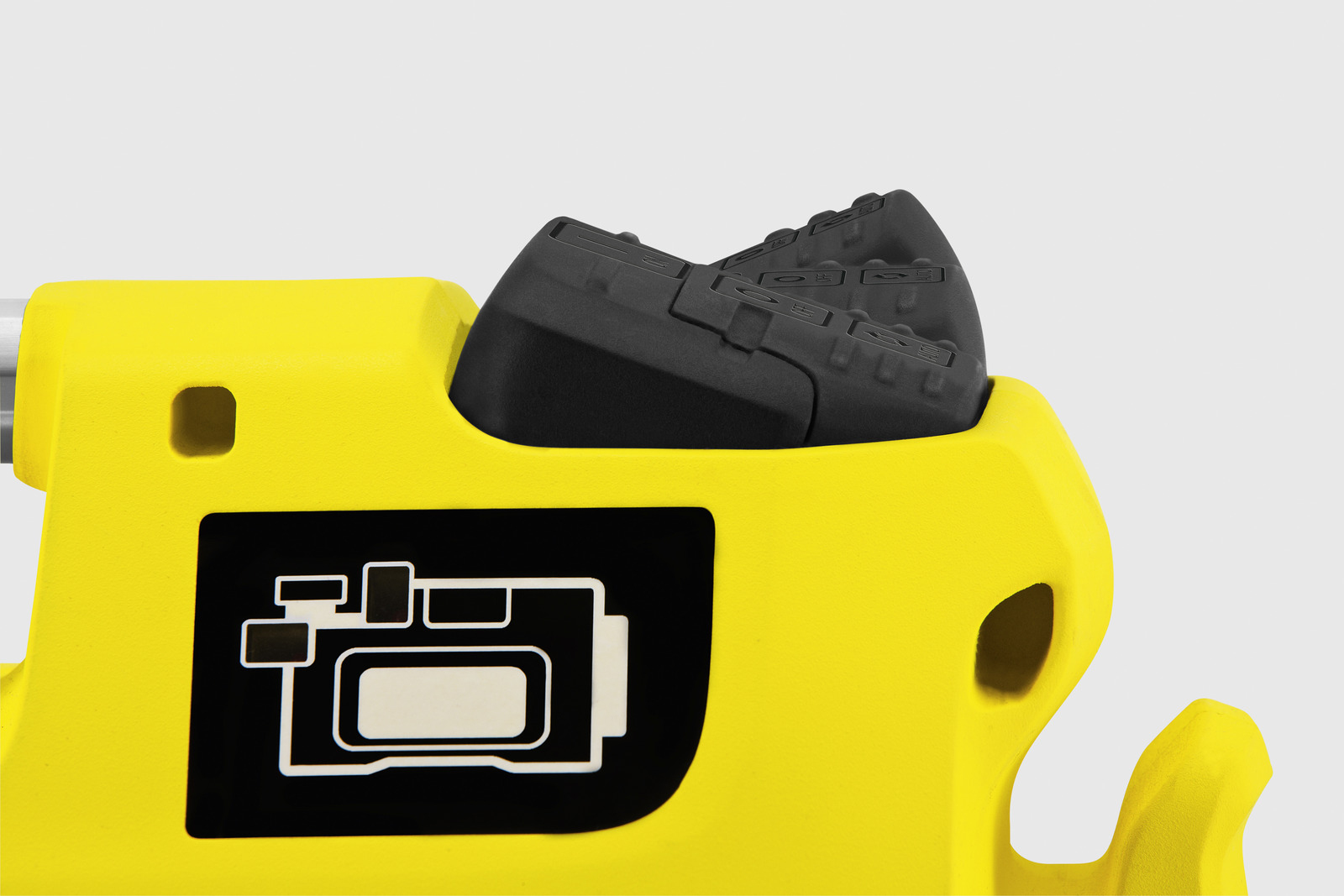Żółte narzędzie z czarnym gumowym uchwytem. Posiada czarny kwadrat z białymi ikonami. Białe tło.