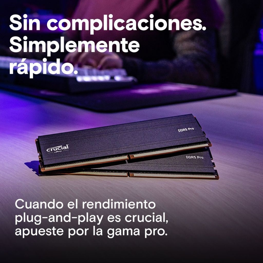 Dwa czarne moduły RAM Crucial DDR5 Pro na drewnianej powierzchni, tekst u góry i na dole. Widoczne dłonie osoby w tle.