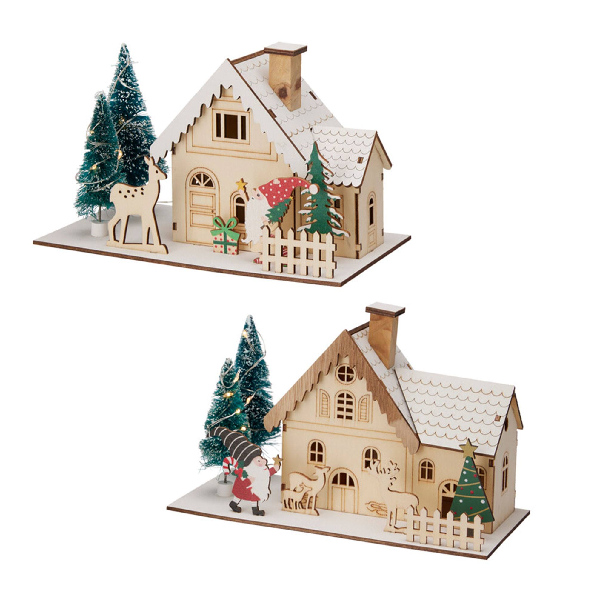 Dos casas navideñas de madera con árboles, ciervos y figuras de Papá Noel. Techos cubiertos de nieve.