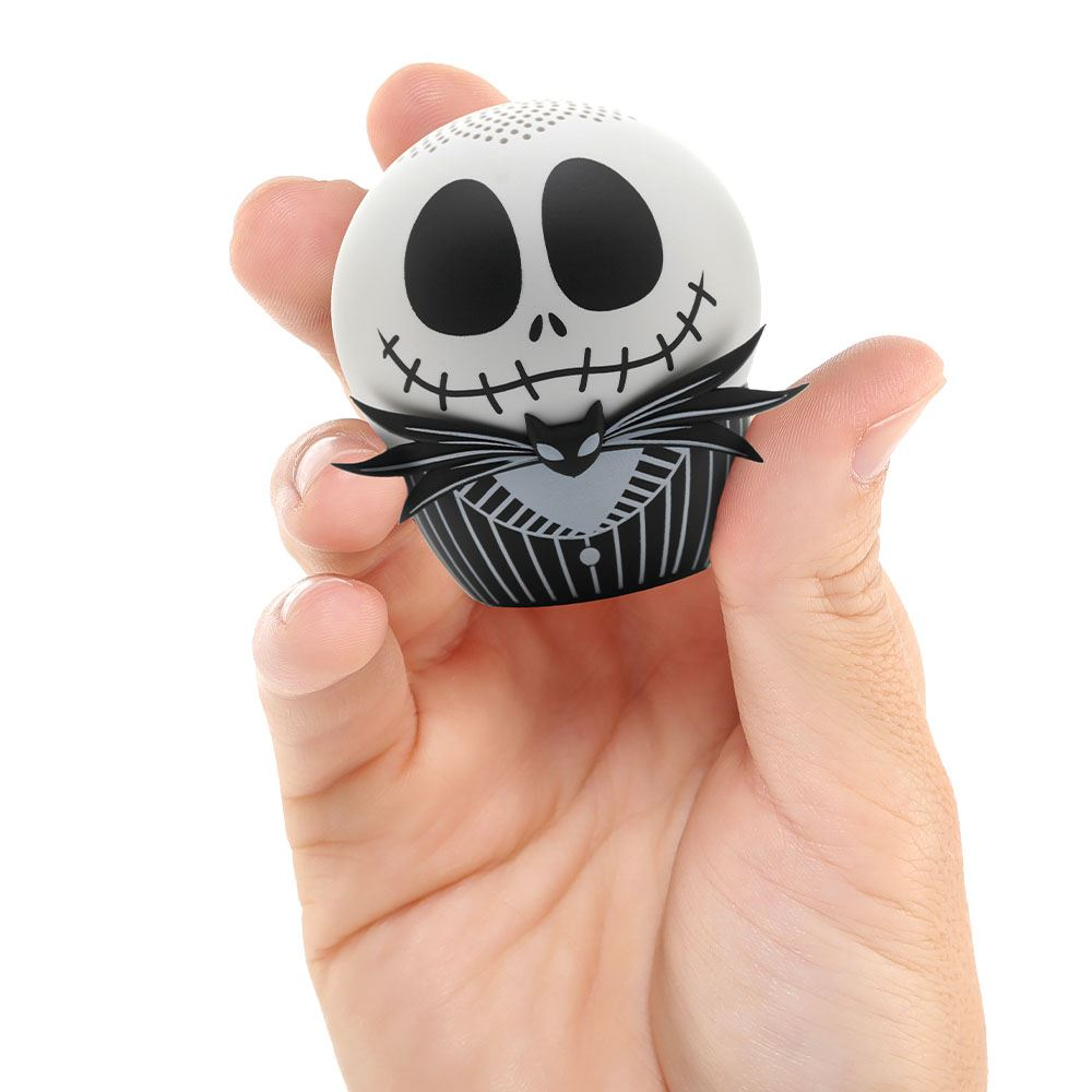 Bir el Jack Skellington figürünü tutuyor. Figür, siyah gözlü ve dikilmiş bir gülümsemesi olan beyaz bir kafaya sahip. Smokin giyiyor.