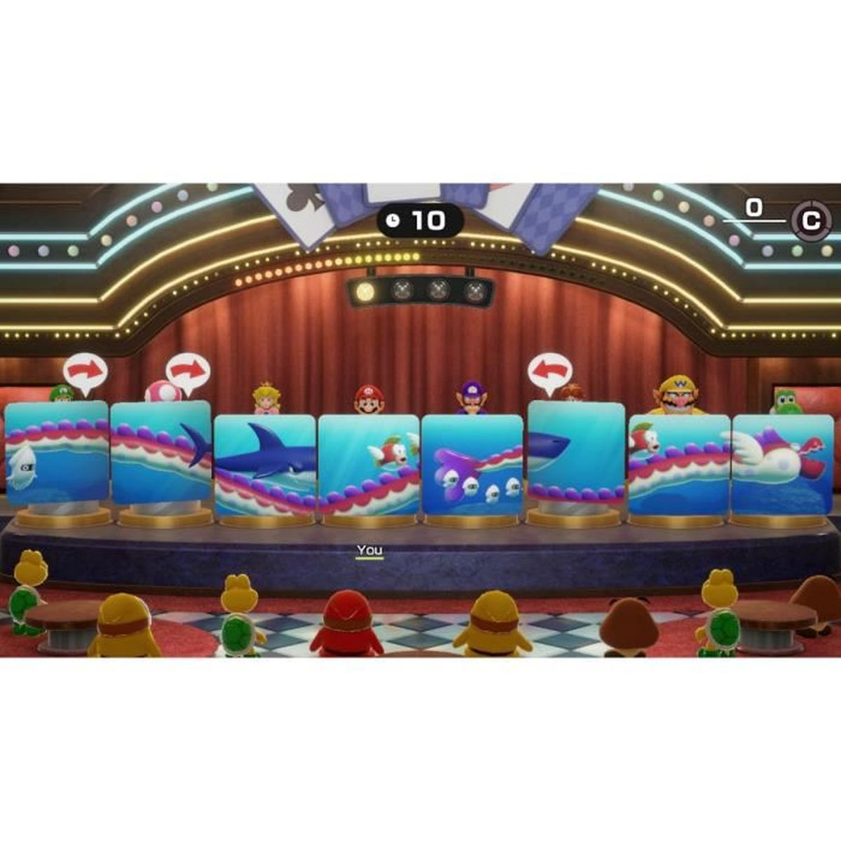 Eine Spielbühne mit Charakteren aus Mario. Hinter blauen Blöcken befinden sich Charaktere. Ein Zähler zeigt 10. Mehrere Charaktere sind im Vordergrund.