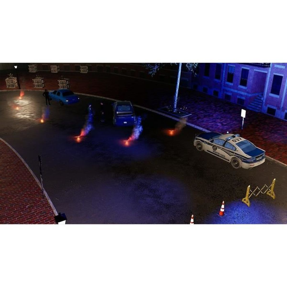 Una scena notturna con auto della polizia e luci di emergenza. Diverse auto per strada. Un edificio visibile sullo sfondo.
