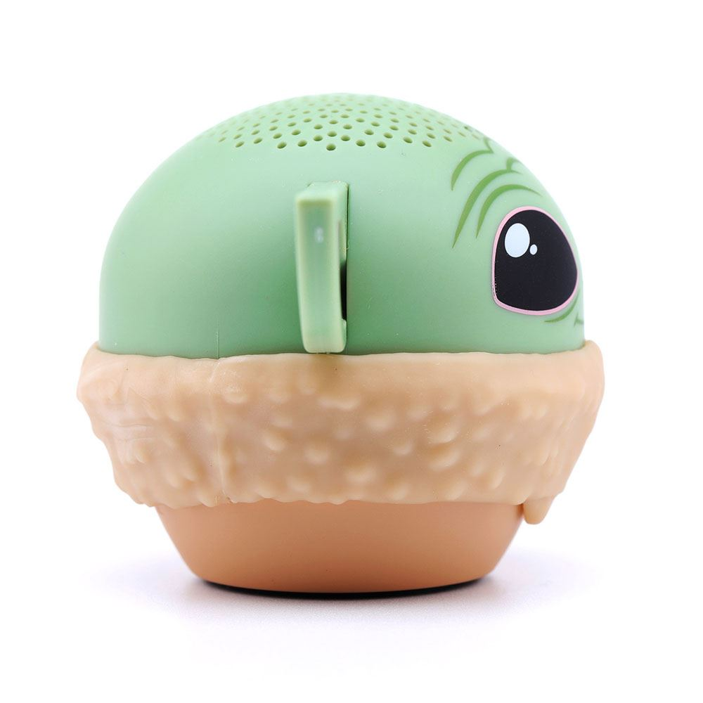 Ein grüner Baby-Yoda-Lautsprecher. Er hat einen beigefarbenen Sockel und einen hellgrünen Kopf mit einem großen Auge.