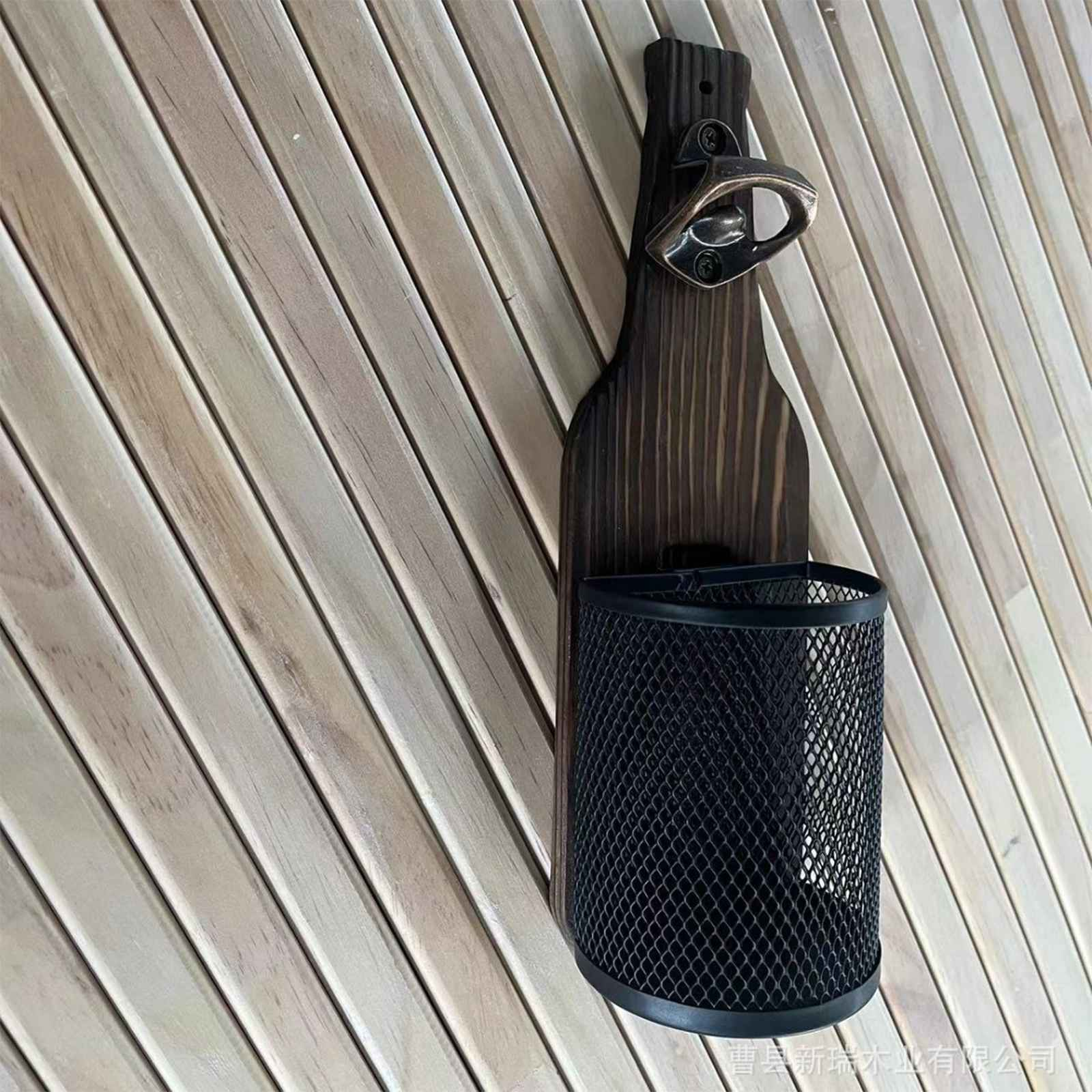 Ein flaschenförmiger Wandflaschenöffner mit Mesh-Becher, vor Holzbrettern.