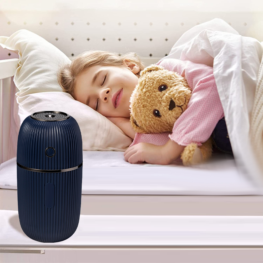 Ein Mädchen schläft in einem Bett und umarmt einen Teddybären. Im Vordergrund steht ein blauer Luftbefeuchter. Die Szene ist friedlich.