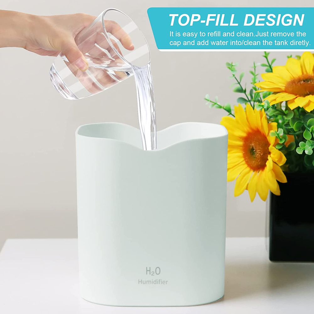 Eine Hand gießt Wasser aus einem Glas in einen hellgrünen Luftbefeuchter. Gelbe Sonnenblumen sind im Hintergrund. Der Text lautet TOP-FILL DESIGN.