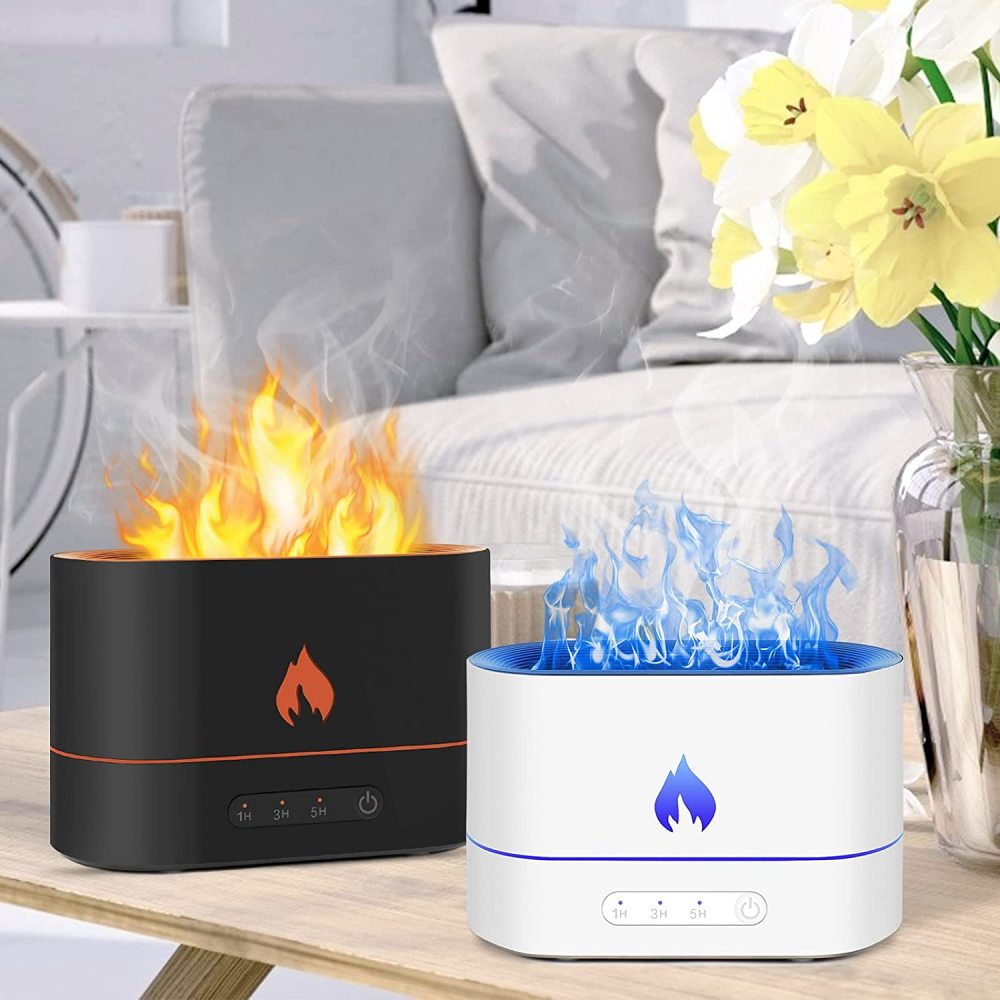 Zwei Geräte mit Flammeneffekt auf einem Tisch. Eines schwarz mit orangenen Flammen, das andere weiß mit blauen Flammen. Hintergrund: Blumen und Sofa.