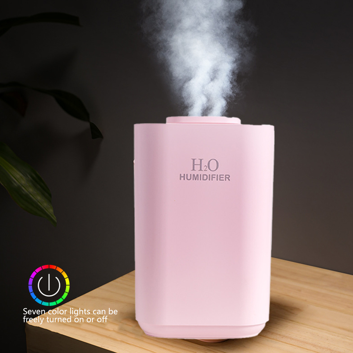 Ein rosa Luftbefeuchter mit aufsteigendem Wasserdampf, der auf einer Holzoberfläche steht. Ein buntes Power-Button-Symbol ist sichtbar.