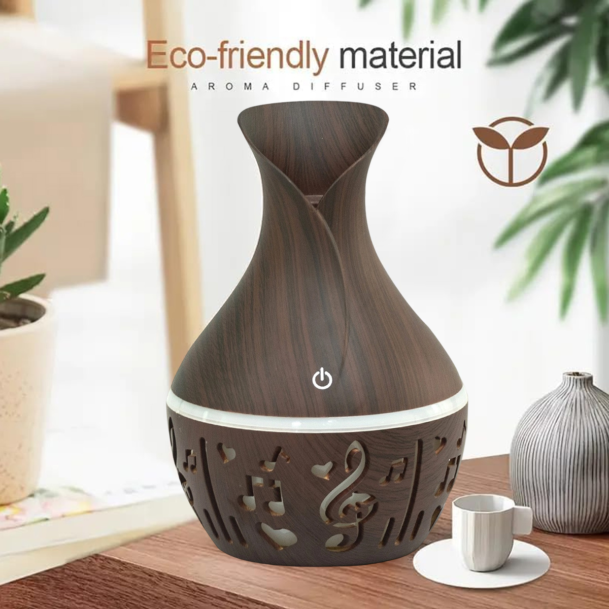 Ein brauner Aromadiffusor mit Notendesign, weißer Basis und einer kleinen Tasse auf einem Holztisch. Hintergrund Pflanzen.