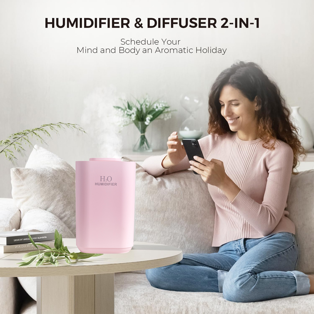 Eine Frau benutzt ein Telefon neben einem rosa Luftbefeuchter. Der Luftbefeuchter steht auf einem Tisch mit Grün. Der Hintergrund hat Blumen und ein Sofa.