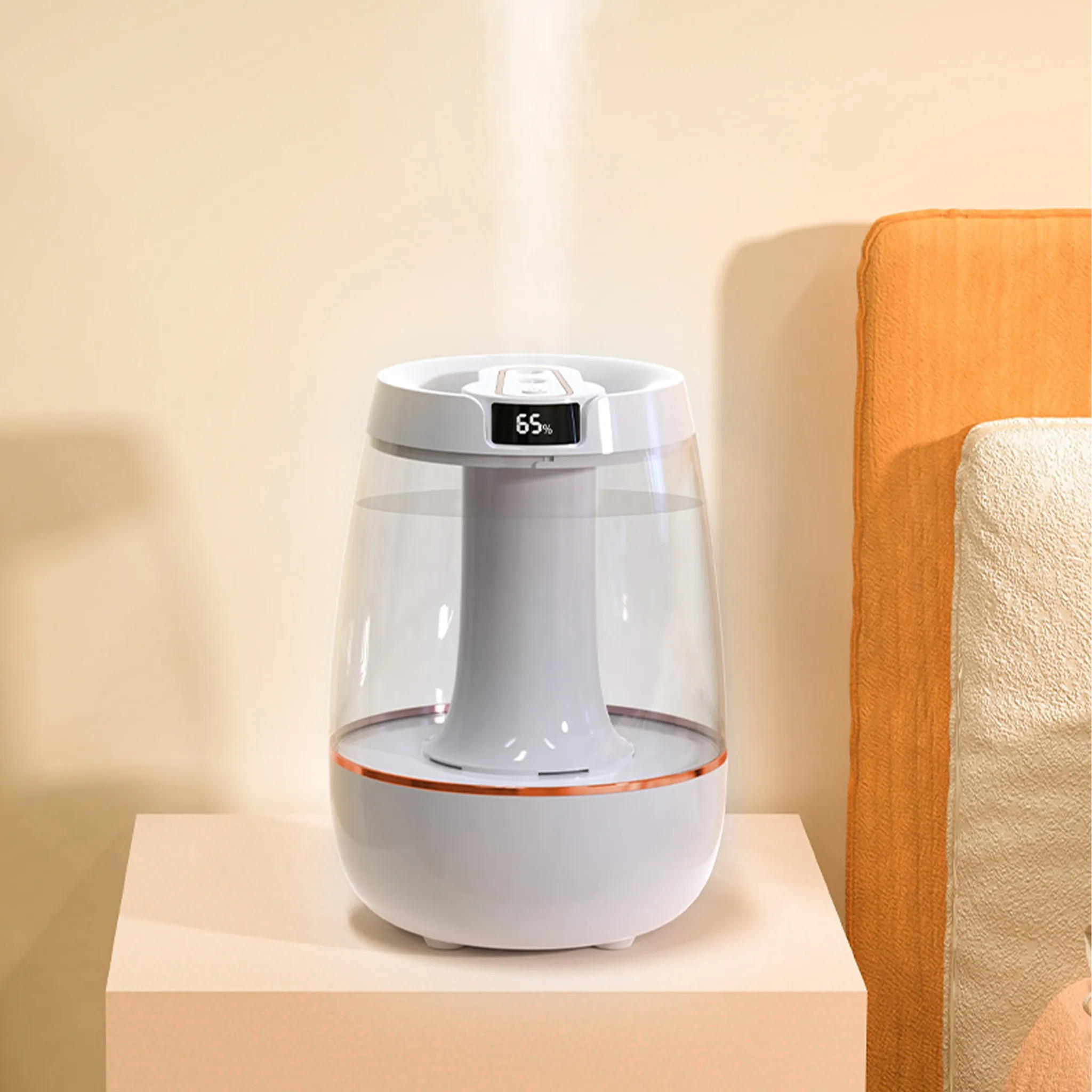 Ein weißer Luftbefeuchter mit transparentem Wassertank. Er steht auf einem beigen Tisch. Rechts ist ein orangefarbenes Kissen.