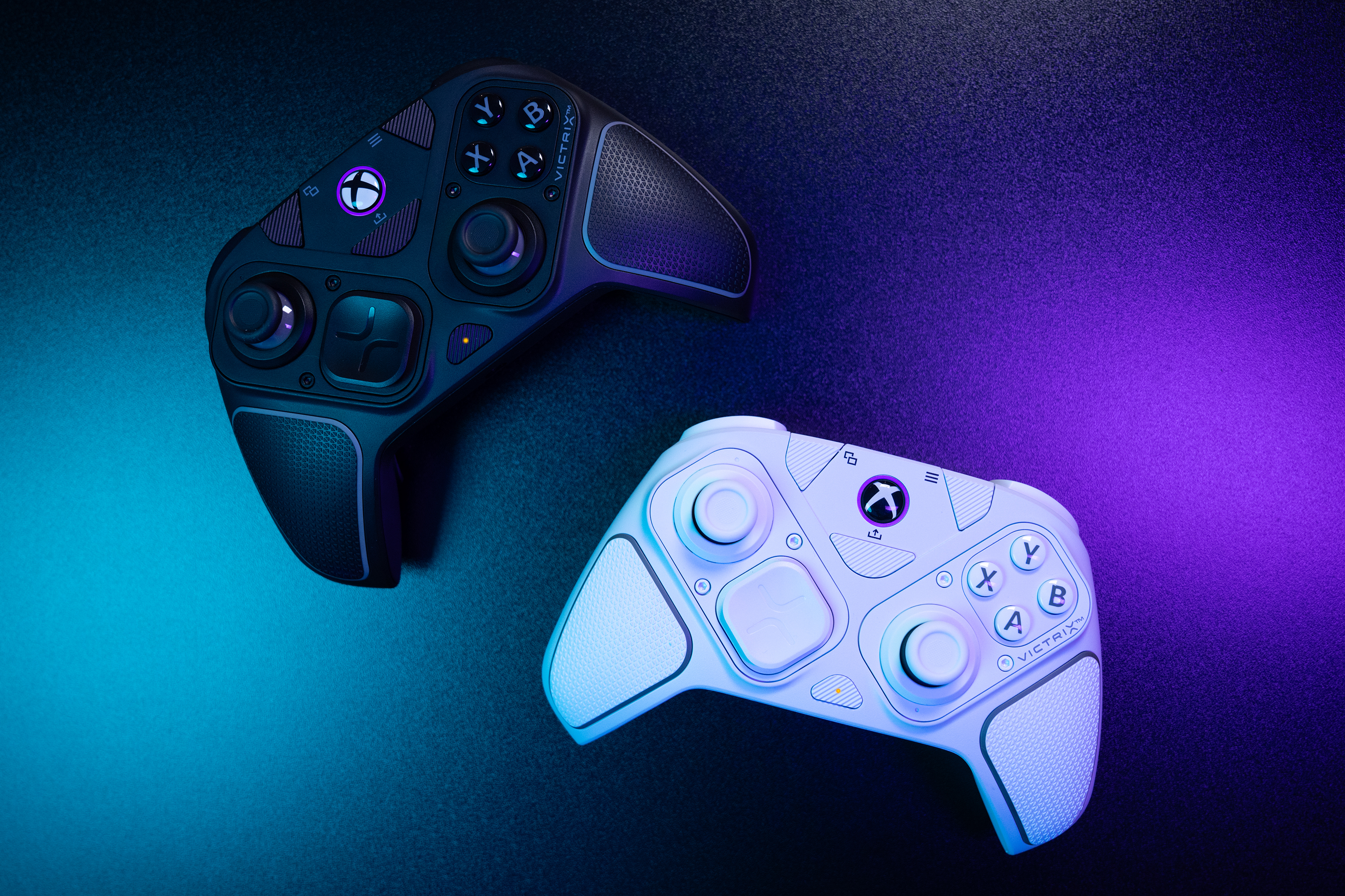 Zwei Gamecontroller, einer schwarz, einer weiß, auf einem lila-blauen Farbverlaufshintergrund.