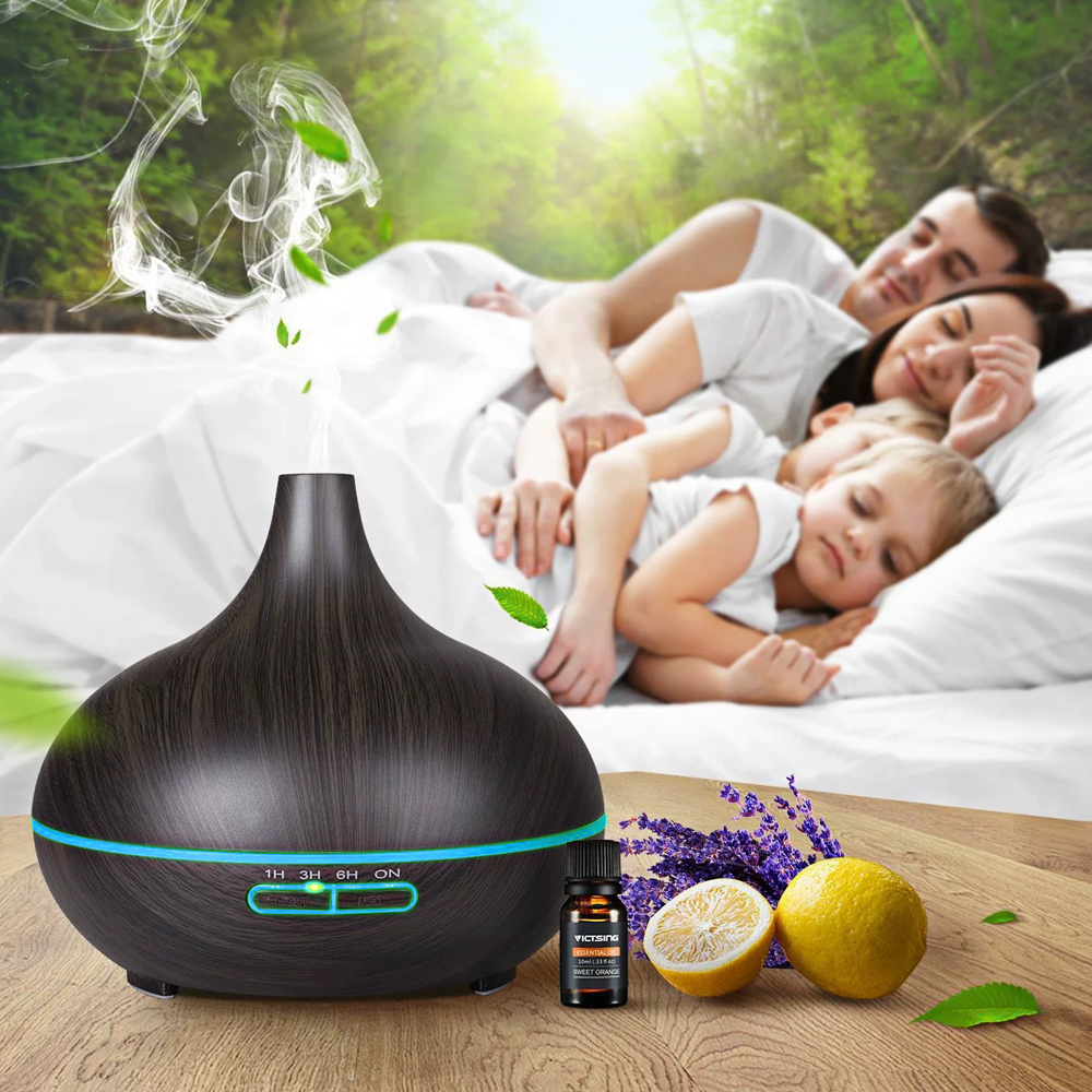 Ein ätherischer Öldiffusor mit einer schlafenden Familie im Hintergrund. Lavendel und Zitronen liegen neben dem Diffusor.
