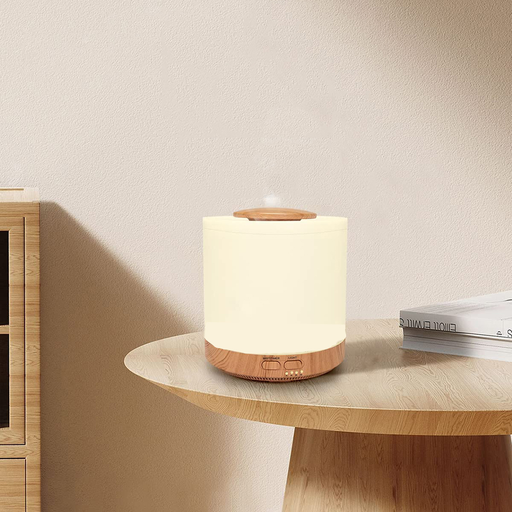 Ein beleuchteter Diffusor auf einem Holztisch. Links ein Holzschrank. Rechts Bücher. Der Hintergrund ist eine beige Wand.