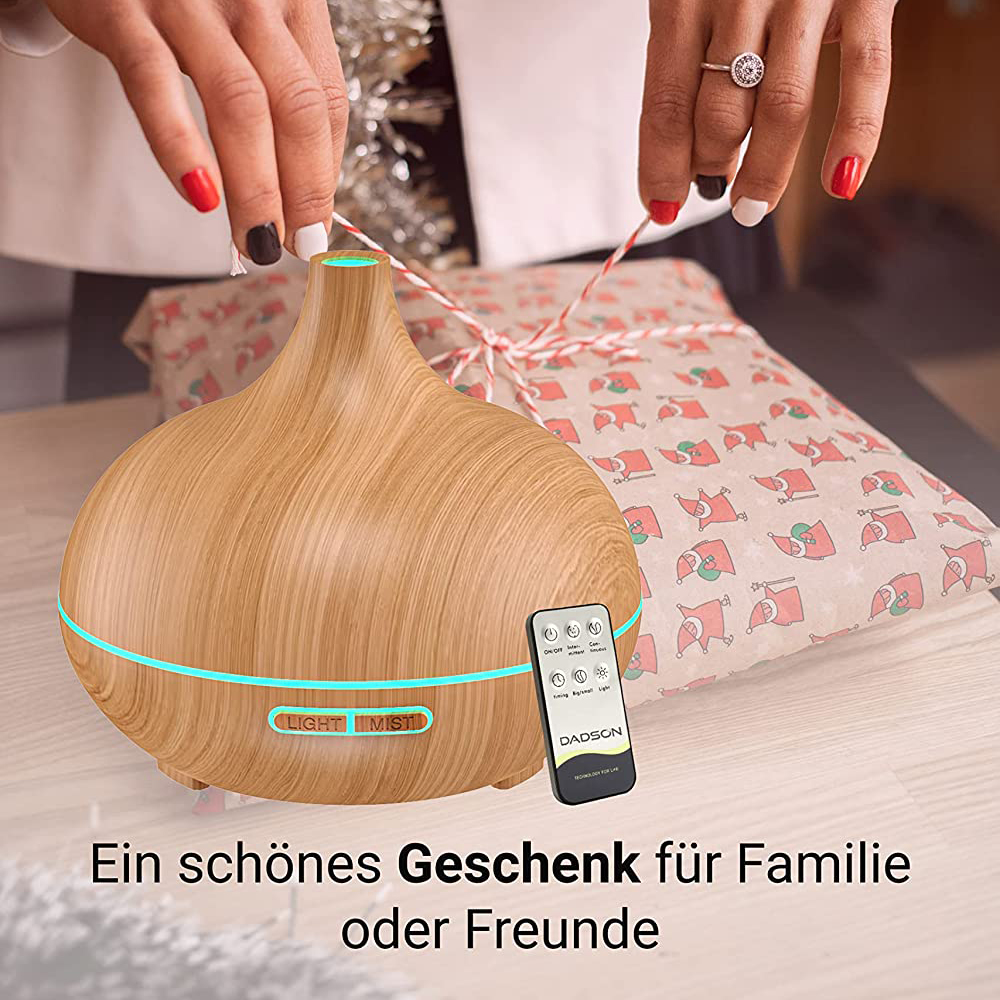 Hände halten eine Schnur über einem Holzdiffusor mit Fernbedienung. Ein Geschenk ist im Hintergrund verpackt.