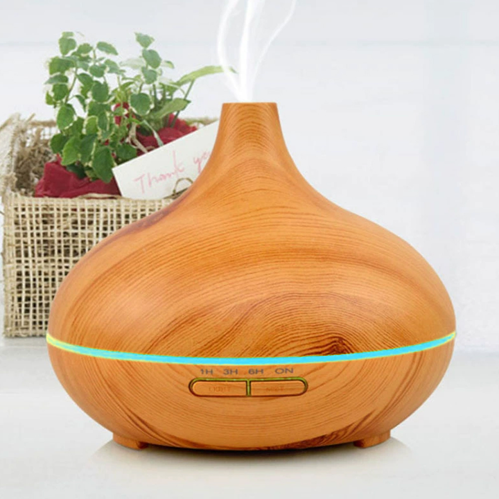 Ein hölzerner Diffusor für ätherische Öle mit Dampf, ein Korb mit einer Pflanze und eine Dankeskarte.