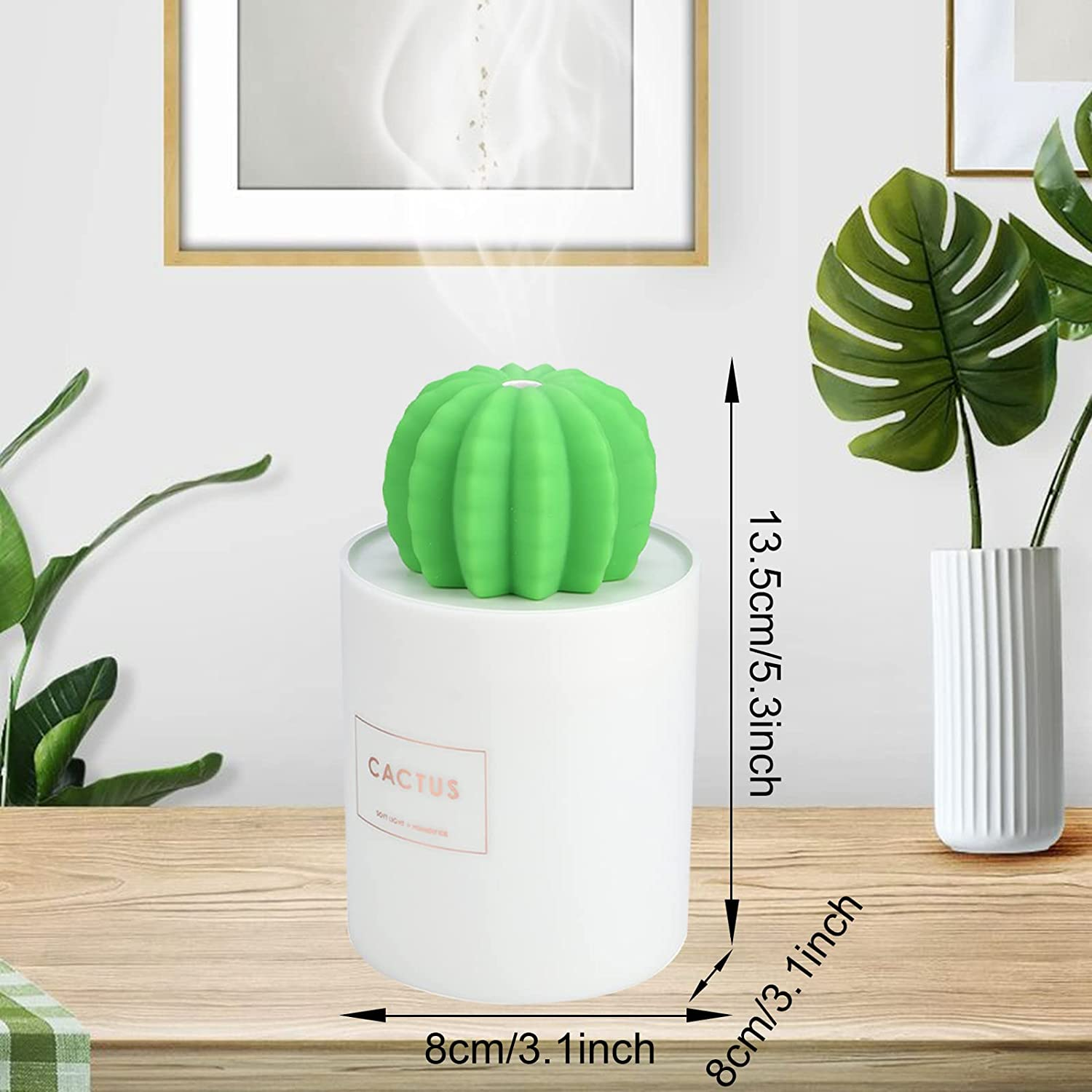 Ein grüner Kaktus-Luftbefeuchter auf weißer Basis. Dampf steigt auf. Pflanzen in weißer Vase auf einem Holztisch. Abmessungen werden gezeigt.