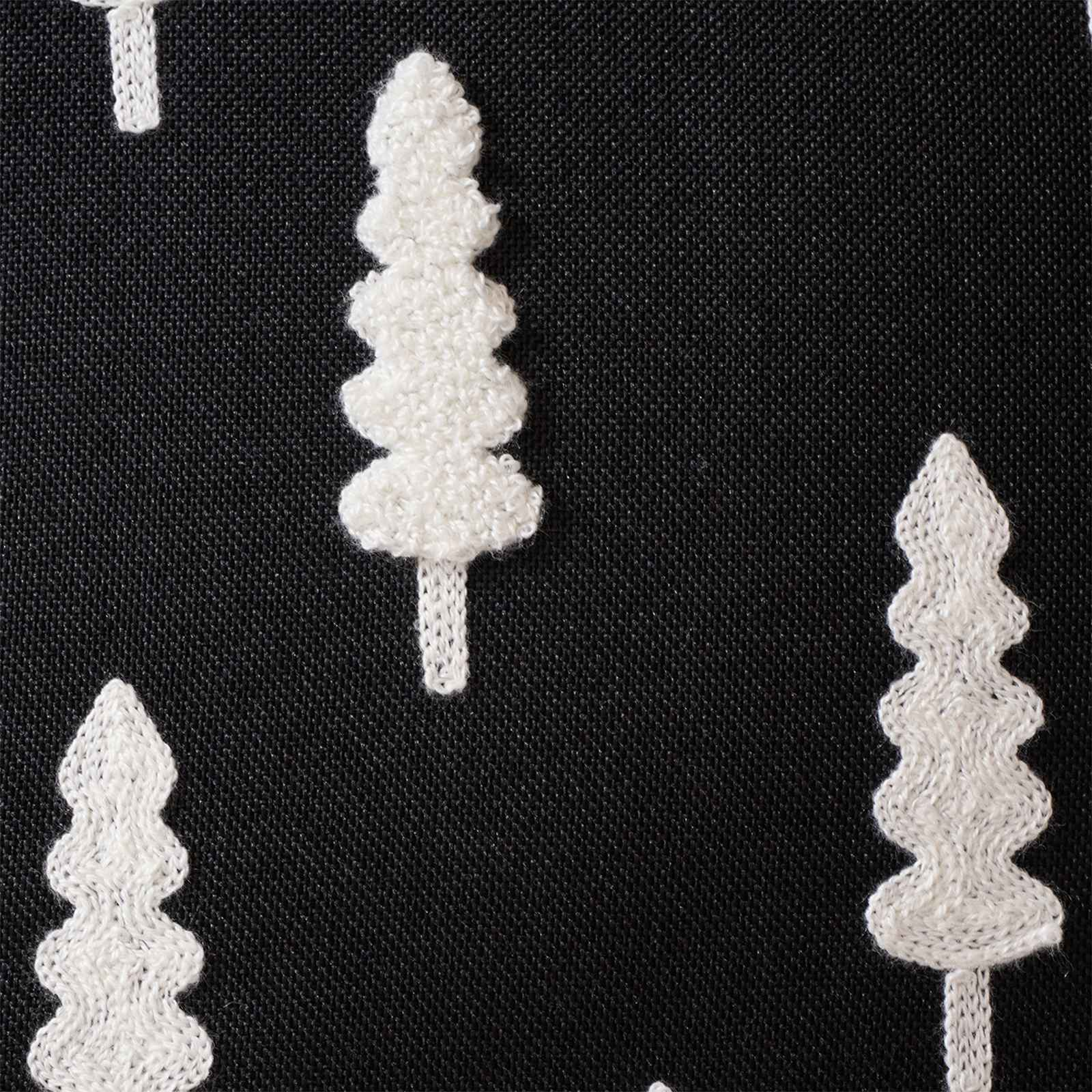 Schwarzer Stoff mit weißen, gestickten Weihnachtsbäumen in verschiedenen Größen. Einige Bäume haben Stiele.