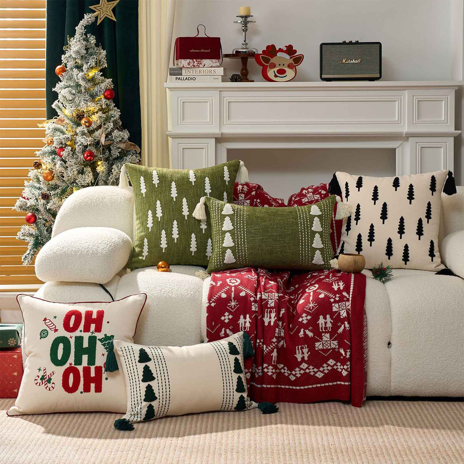 Eine festliche Wohnzimmerszene mit einem geschmückten Weihnachtsbaum, Kissen und einer roten Decke auf einem weißen Sofa.