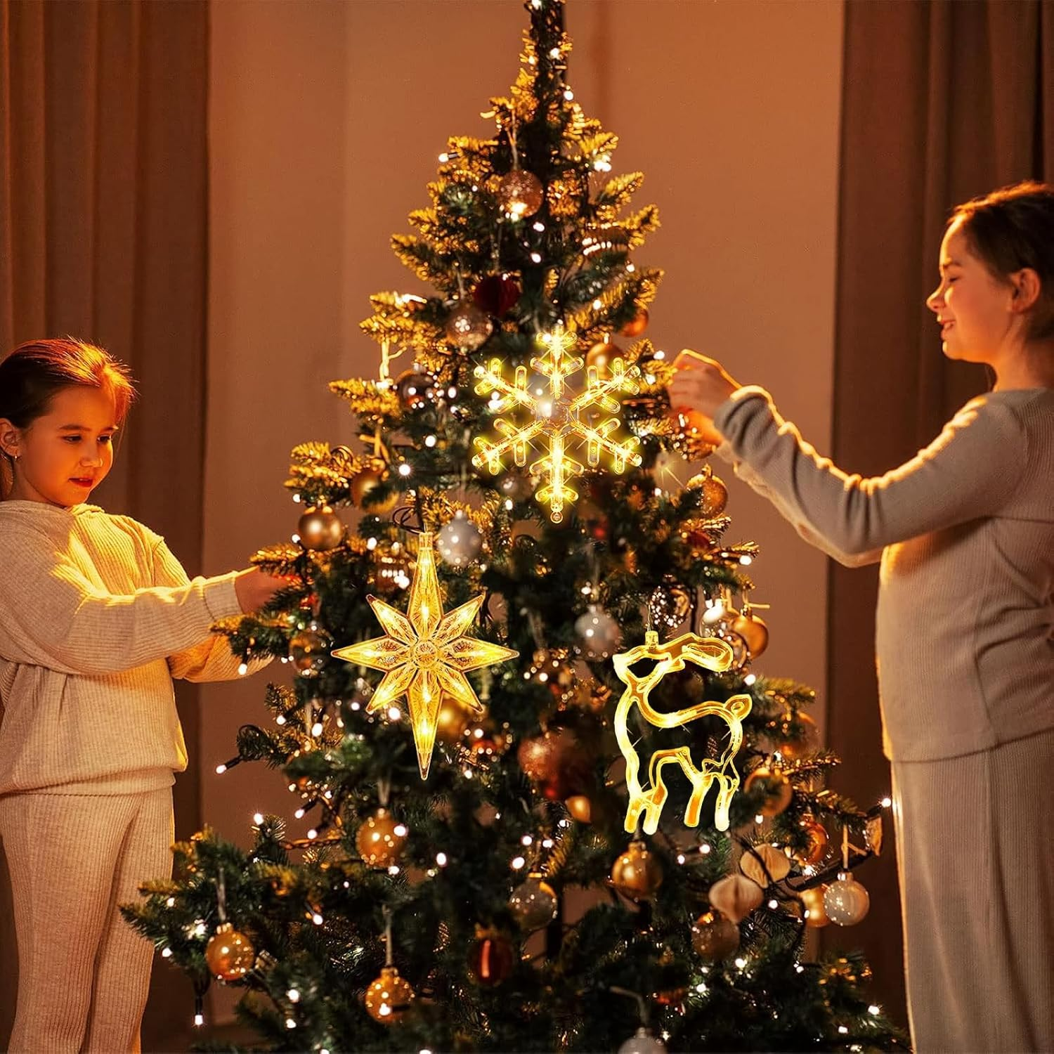 Eine Frau und ein Mädchen schmücken einen Weihnachtsbaum mit beleuchteten Ornamenten.