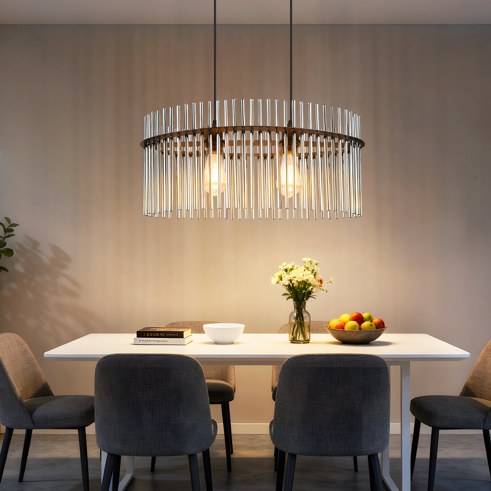 Un comedor con mesa blanca, sillas, lámpara de araña, flores y frutero. Iluminación cálida.